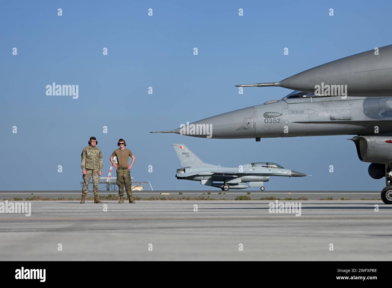 Michael Kaminski, Senior Airman der US Air Force F-16 Kampffalken-Crew-Chef, führt am 7. Januar 2024 an einem unbekannten Ort im Verantwortungsbereich des US-Zentralkommandos eine multifunktionale Airman-Ausbildung an Senior Airman Philip Miller, einem Traffic Management Craftsman, für Übung Ballast Cannon 24,3 durch. Übung Ballast Cannon tritt fast vierteljährlich mit der Royal Bahraini Air Force auf, um die schnellen Expeditionsfähigkeiten der U.S. Air Force durch die Integration von Agile Combat Employment Objectives für F-16 Fighting Falcon, KC-135 Stratotanker und operativer Unterstützung per zu unterstützen Stockfoto