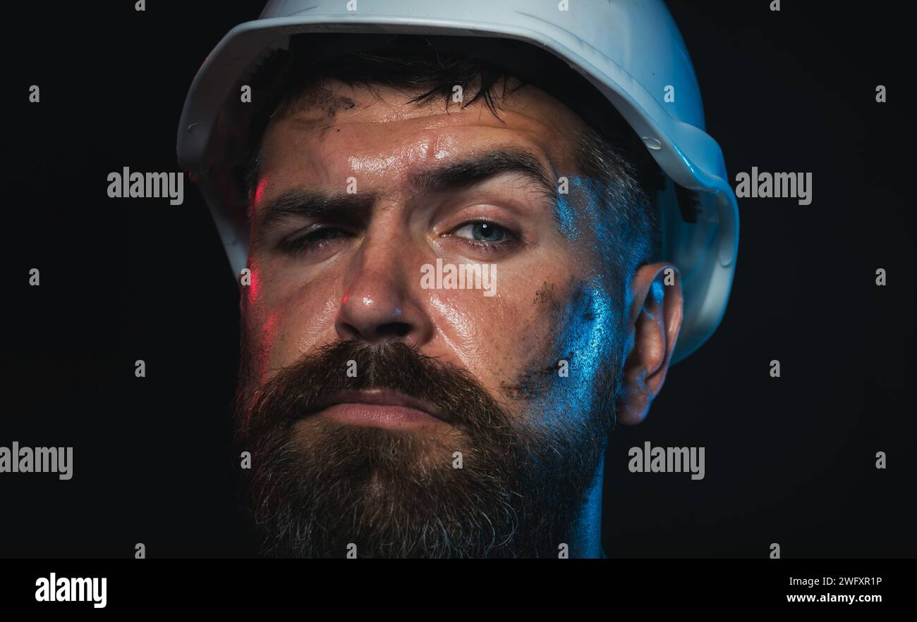 Nahaufnahme-Porträt eines Bauarbeiters mit Schutzhelm. Seriöser Baumeister, Architekt oder Ingenieur im Schutzhelm. Harte Arbeit. Bärtiger Bergmann oder Stockfoto