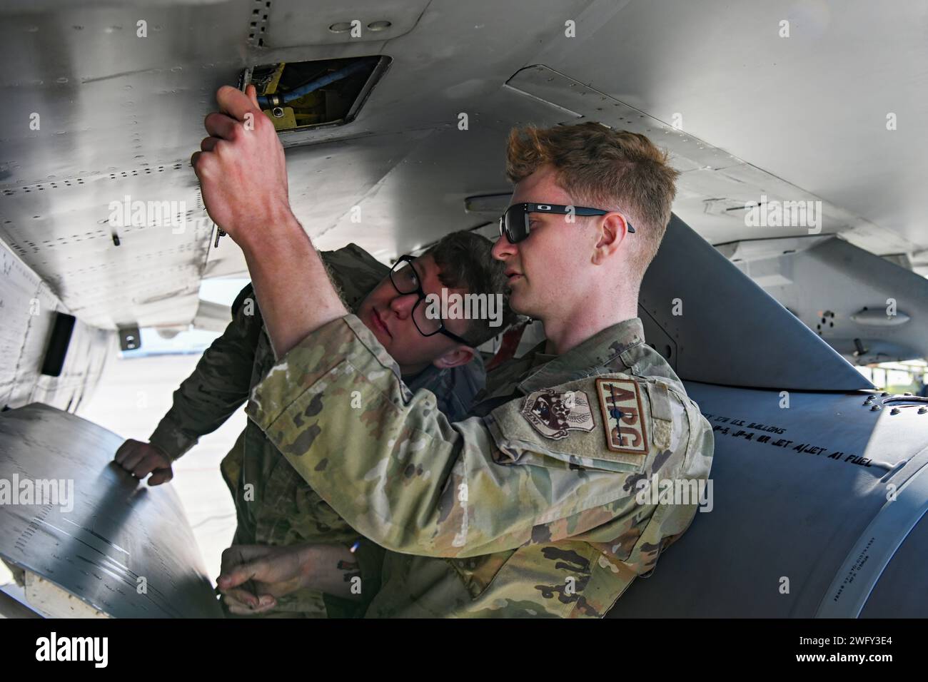 Philip Miller, Back, ein Traffic Management Craftsman, erhält ein multifunktionales Airman Training von Senior Airman Michael Kaminski, Front, einem F-16 Kampffalken-Crew-Chef der US Air Force, für Übung Ballast Cannon 24,3 an einem unbekannten Ort im US Central Command Area of Responsibility, 7. Januar, 2024. Übung Ballast Cannon tritt fast vierteljährlich mit der Royal Bahraini Air Force auf, um die schnellen Expeditionsfähigkeiten der U.S. Air Force durch die Integration von Agile Combat Employment Objectives für F-16 Fighting Falcon, KC-135 Stratotanker und Operational zu unterstützen Stockfoto