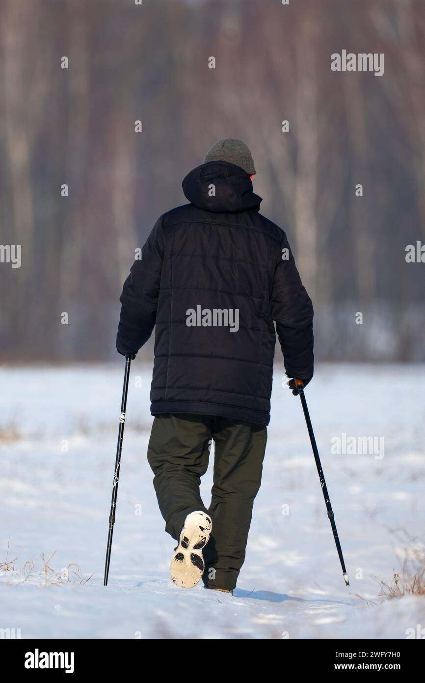 Ein Mann, der im Winter Nordic Walking praktiziert Stockfoto