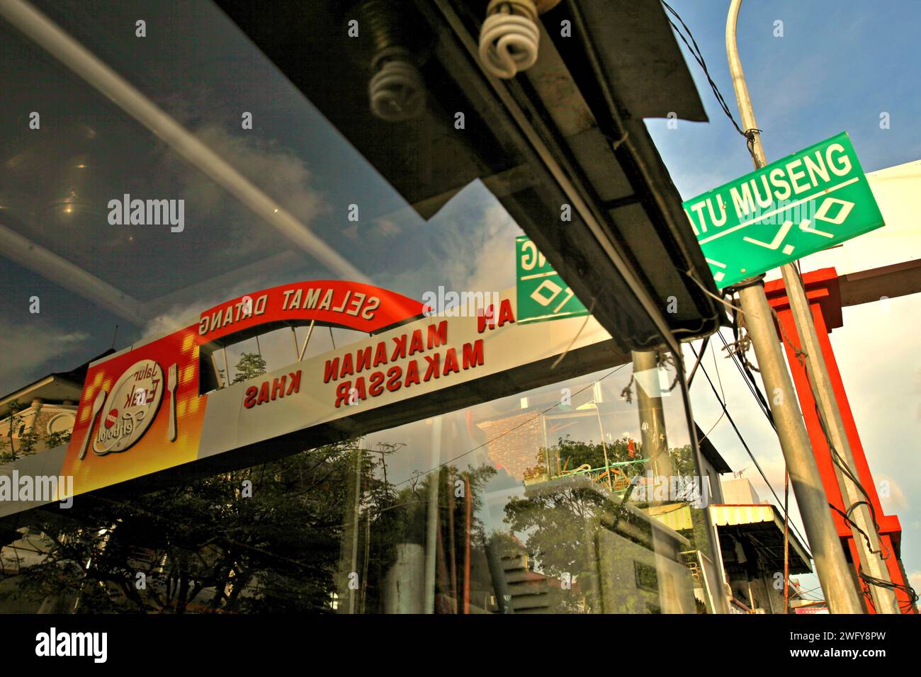 Glasreflexion des Tors der Datu (Datuk) Museng Straße, Zentrum der kulinarischen Geschäfte und Cafés in Makassar, Süd-Sulawesi, Indonesien. Stockfoto