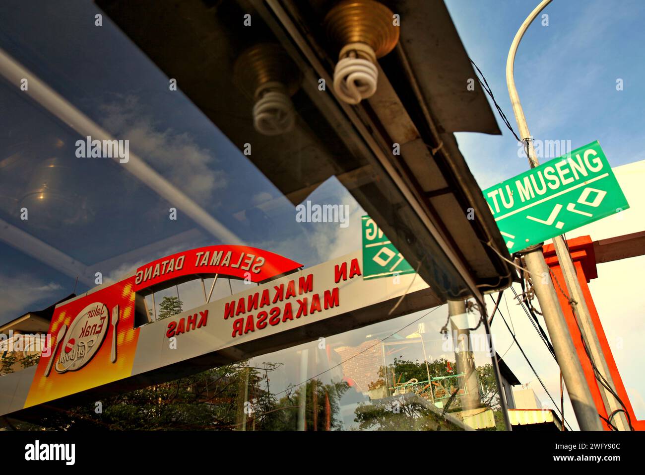 Glasreflexion des Tors der Datu (Datuk) Museng Straße, Zentrum der kulinarischen Geschäfte und Cafés in Makassar, Süd-Sulawesi, Indonesien. Stockfoto