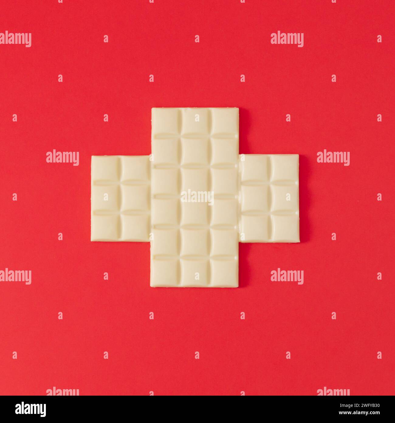 Flagge der Schweiz mit weißer Schokolade. Realistischer ästhetischer Look. Minimales Konzept. Trendige Schweizer Flagge und weiße Schokolade. Stockfoto
