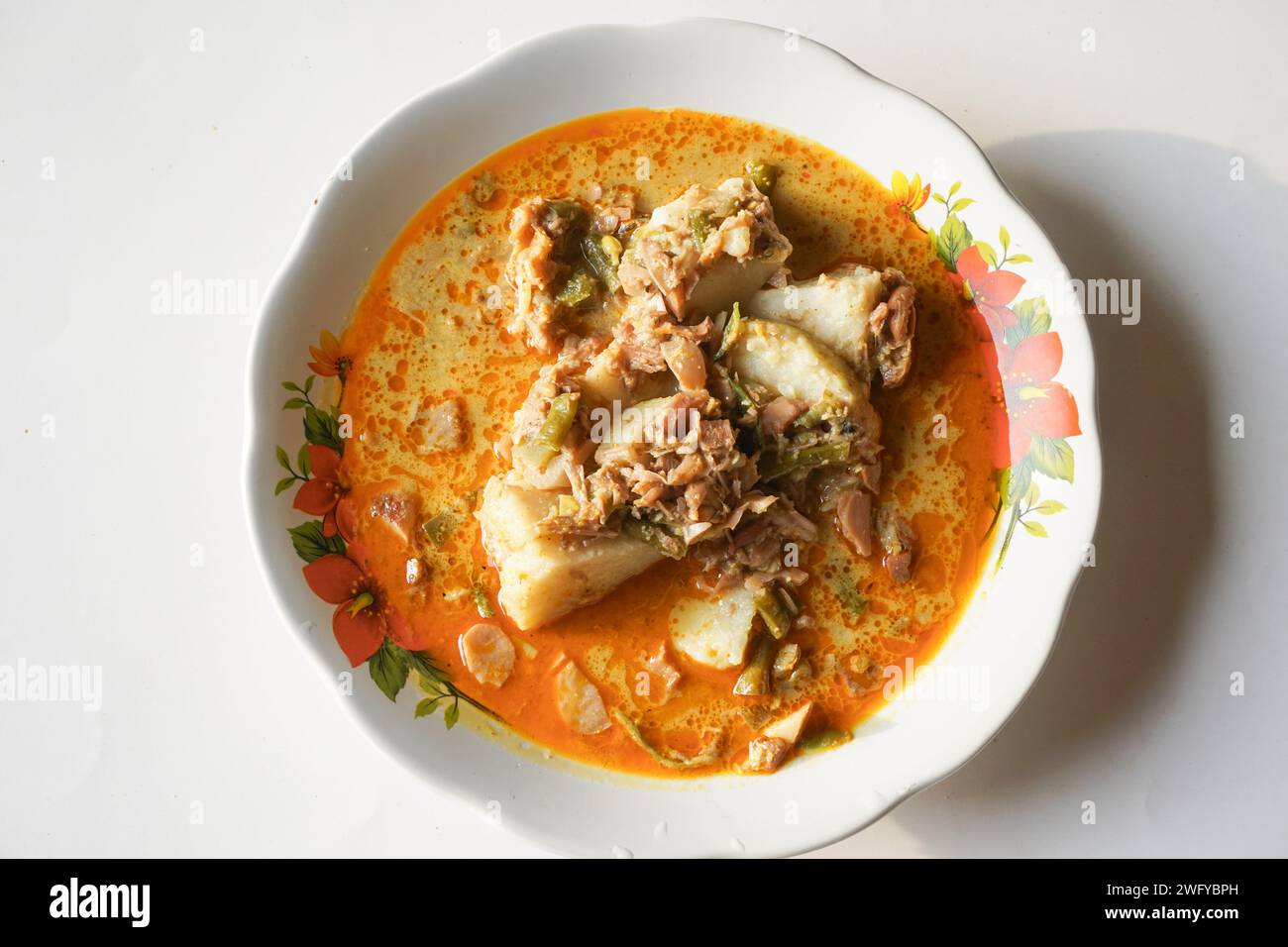 Lontong Sayur oder Gemüsereis Kuchen ist ein typisches indonesisches Essen auf einer weißen Platte mit isoliertem weißem Hintergrund Stockfoto