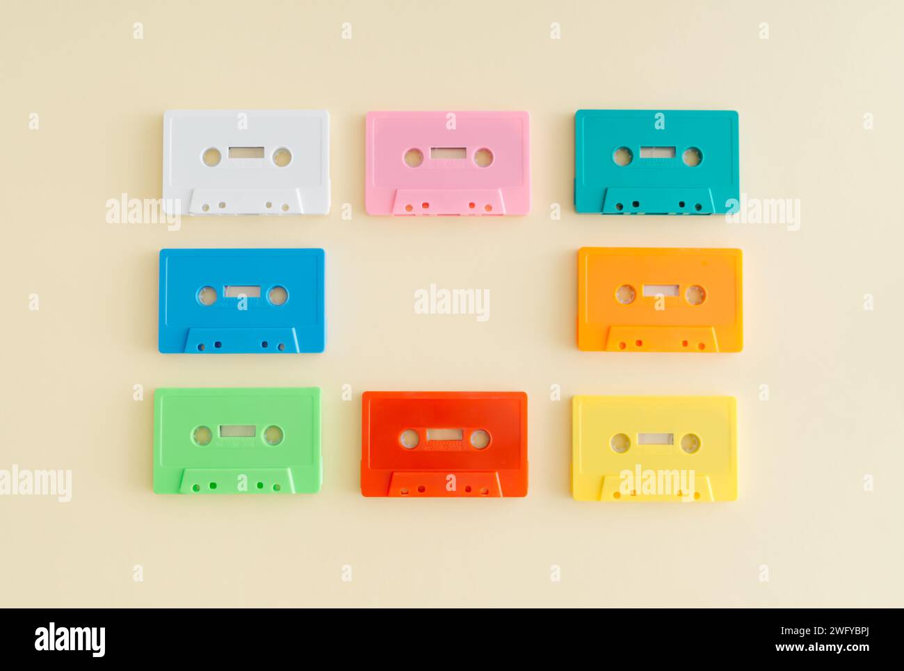 Layout von bunten Retro-Audiokassetten auf pastellbeigem Hintergrund. Kreatives Konzept der Retro-Technologie. Ästhetik der 80er Jahre. Vintage-Audiokassette Stockfoto