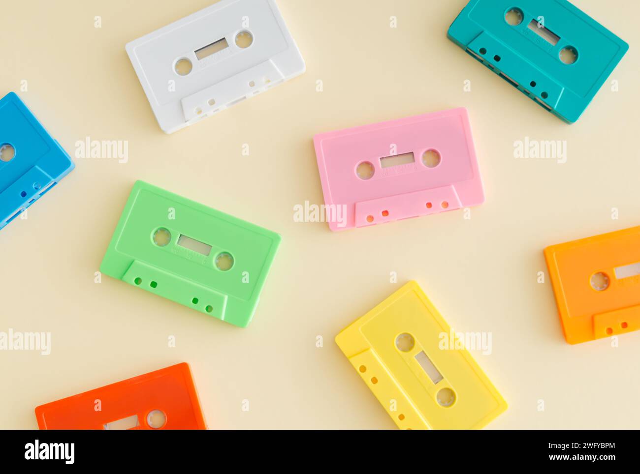 Muster von bunten Retro-Audiokassetten auf pastellfarbenem beigem Hintergrund. Kreatives Konzept der Retro-Technologie. Ästhetik der 80er Jahre. Vintage-Audiokassett Stockfoto