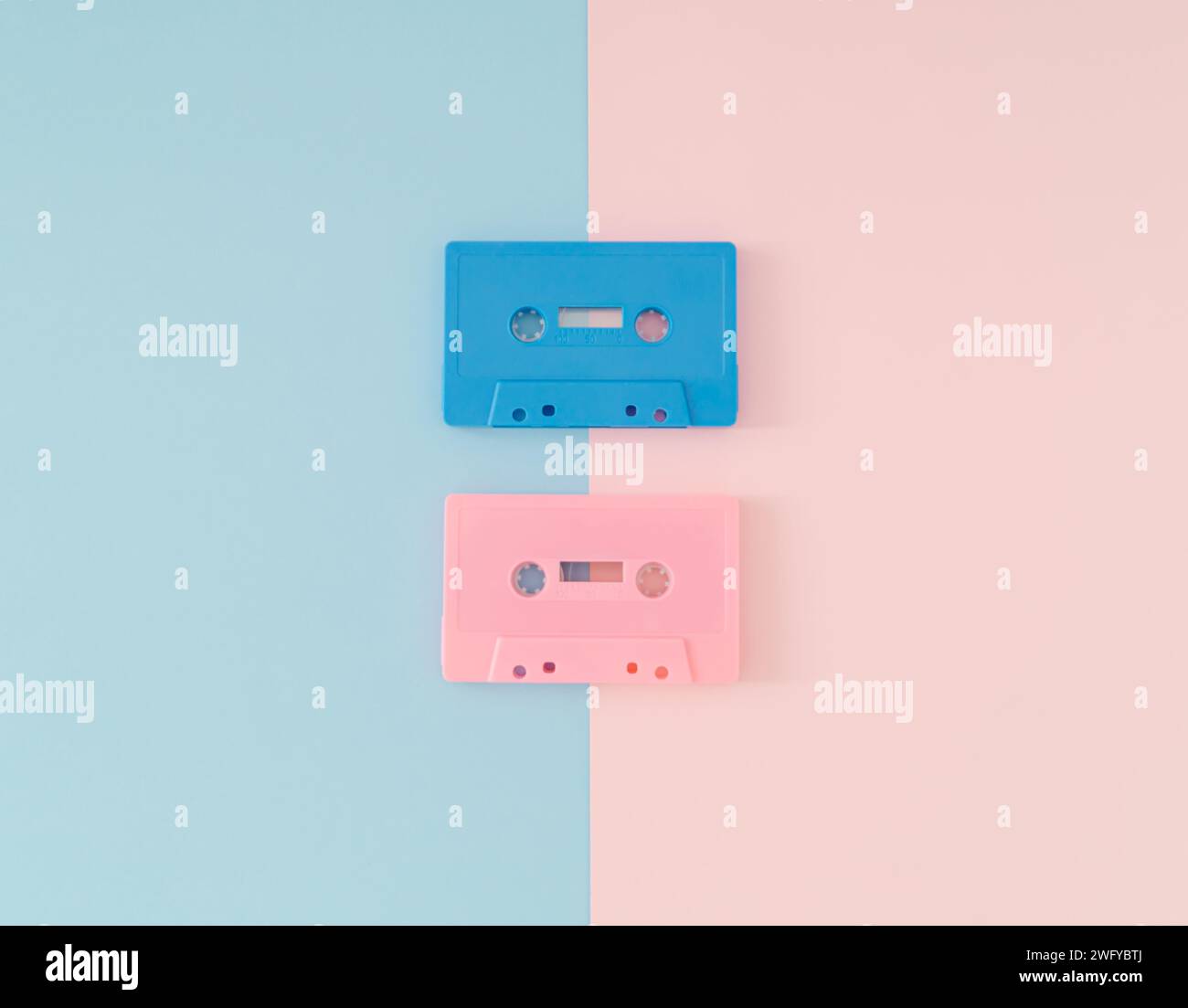 Layout der rosafarbenen und blauen Audiokassettenbänder im Retro-Stil auf hellem pastellrosa und blauem Hintergrund. Kreatives Konzept der Retro-Technologie. Ästhetik der 80er Jahre. Stockfoto
