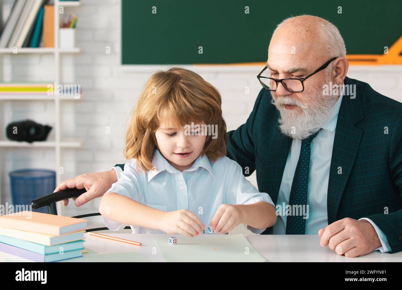 Oberlehrer oder Großvater und Schüler im Klassenzimmer der Schule. Privatunterricht. Alte Tutor Lehrer helfen kleinen Jungen Schüler mit dem Studium der Mathematik Stockfoto