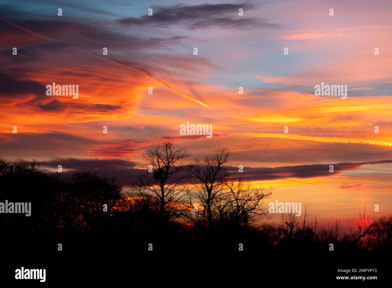 Die Staubwolke aus der Sahara erzeugt einen spektakulären Himmel bei Sonnenuntergang über England Großbritannien mit einer Silhouette der Skyline Stockfoto