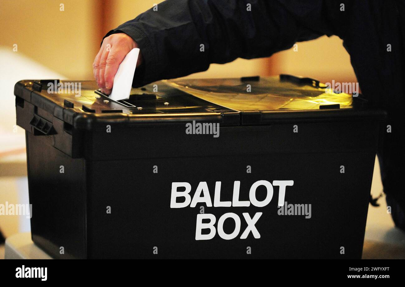 Aktenfoto vom 05/10 eines Wählers, der einen Wahlzettel in die Wahlurne in der Markthalle in Swadlincote, Derbyshire, platziert. Die SNP und Labour werden bei den nächsten Parlamentswahlen dieselbe Anzahl von Sitzen gewinnen, schlägt eine neue Umfrage vor. Eine Umfrage der Beratungsfirma True North by Survation befragte zwischen dem 23. Und 25. Januar 1.029 Personen und stellte Humza Yousafs Partei auf 36 % der entschiedenen Wähler, während Labour auf 34 % steht. Ausgabedatum: Freitag, 2. Februar 2024. Stockfoto