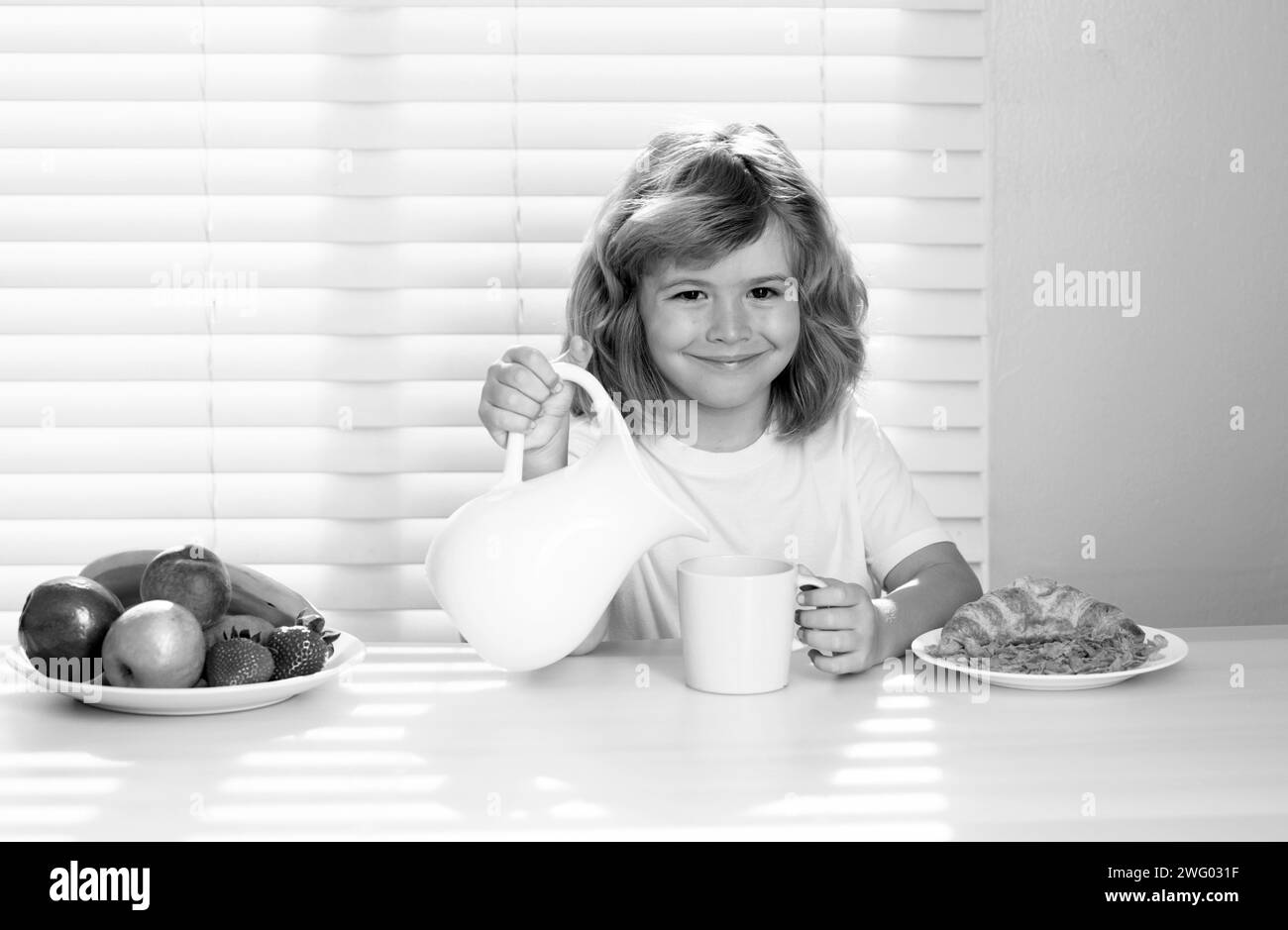 Pretten-Kind gießt ganze Kuhmilch. Der Schüler frühstückt vor der Schule. Porträt des Kindes sitzen am Schreibtisch zu Hause Küche haben köstliche leckere Nu Stockfoto