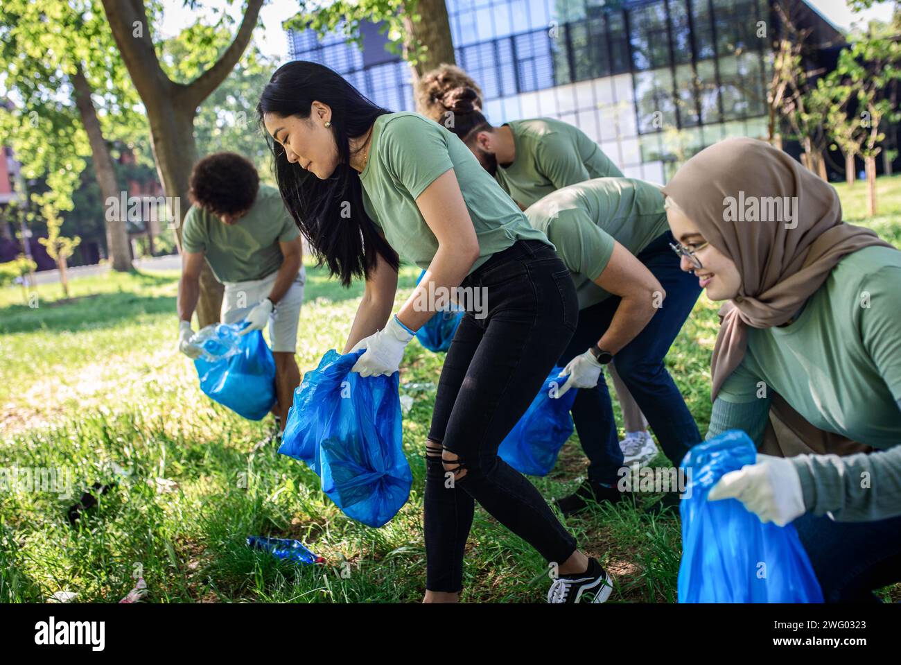 Multiethnische Gruppe von Freiwilligen mit Müllsäcken, die den Stadtpark reinigen. Stockfoto
