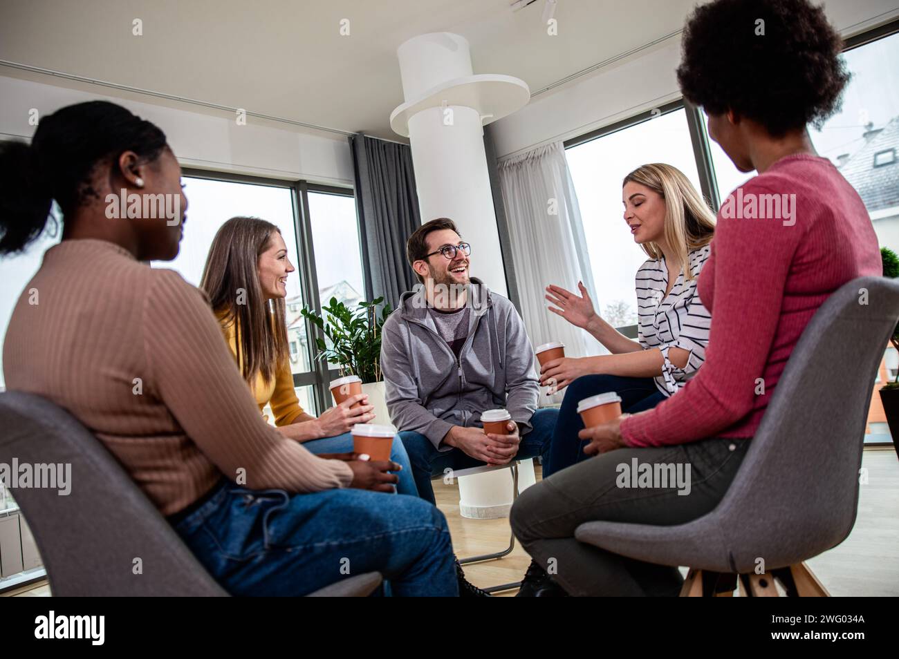 Verschiedene Gruppen von Personen, die in Gruppentherapiesitzungen im Kreis sitzen. Stockfoto