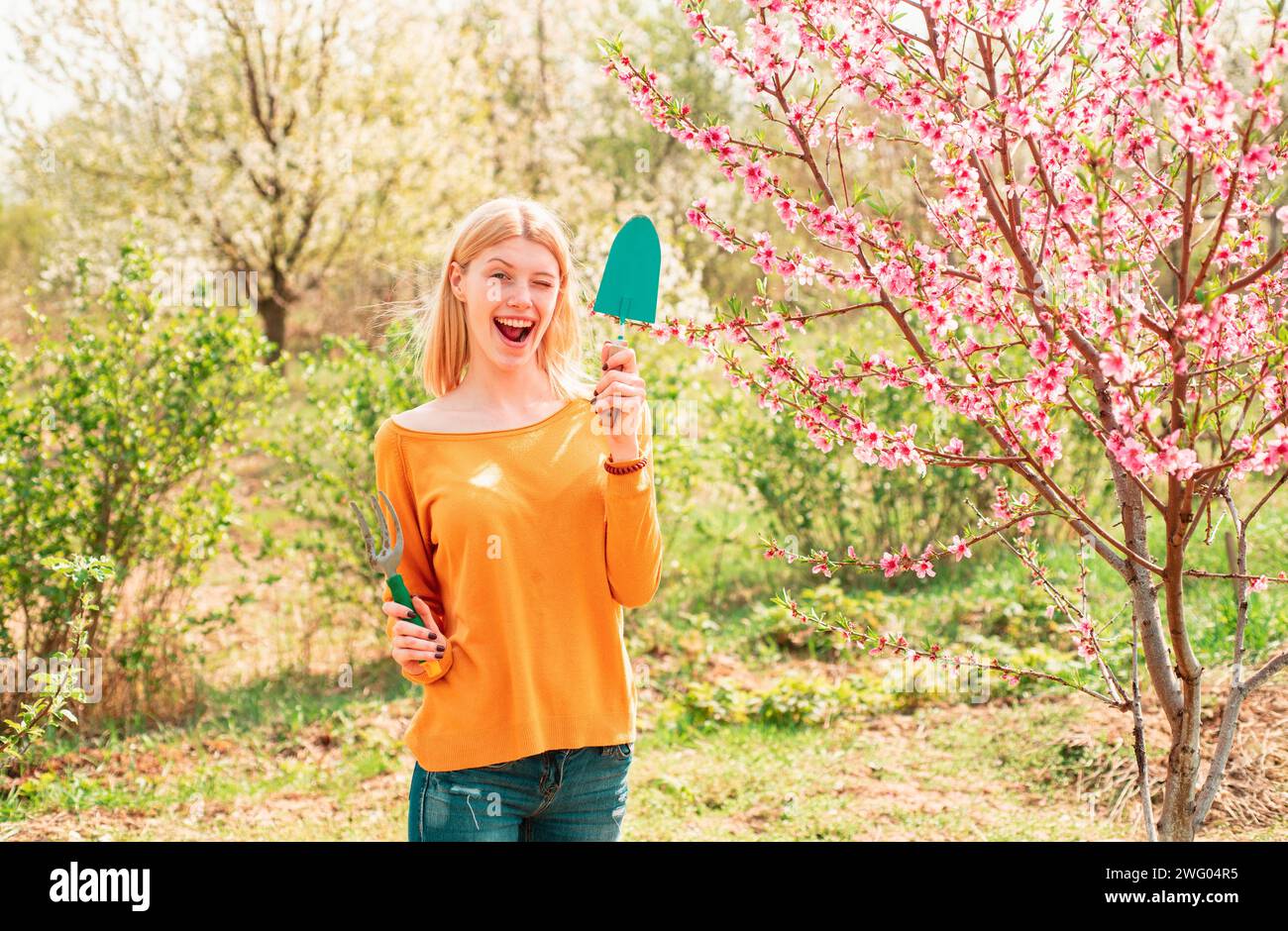Gärtnerin Mädchen, die im Frühlingsgarten zuzwinkern Stockfoto