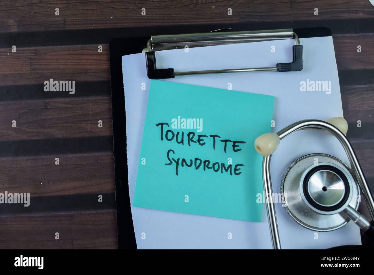 Konzept des Tourette-Syndroms Schreiben auf Haftnotizen mit Stethoskop isoliert auf Holztisch. Stockfoto