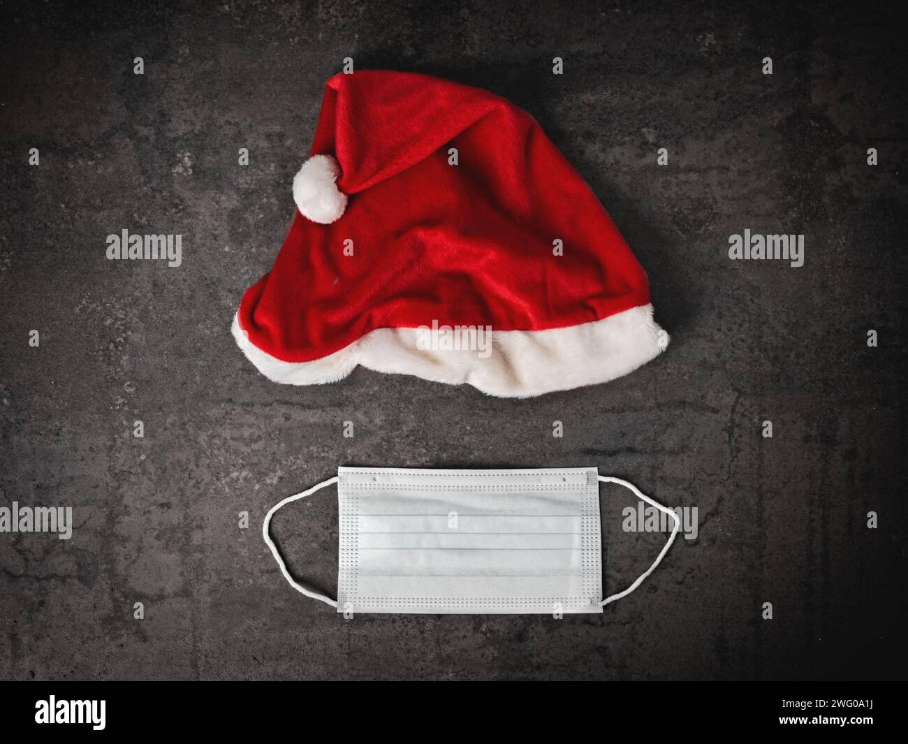 Santa Claus Hut und medizinische Maske direkt oben gesehen. Quarantäne während des Weihnachtsferien-Konzepts. Stockfoto