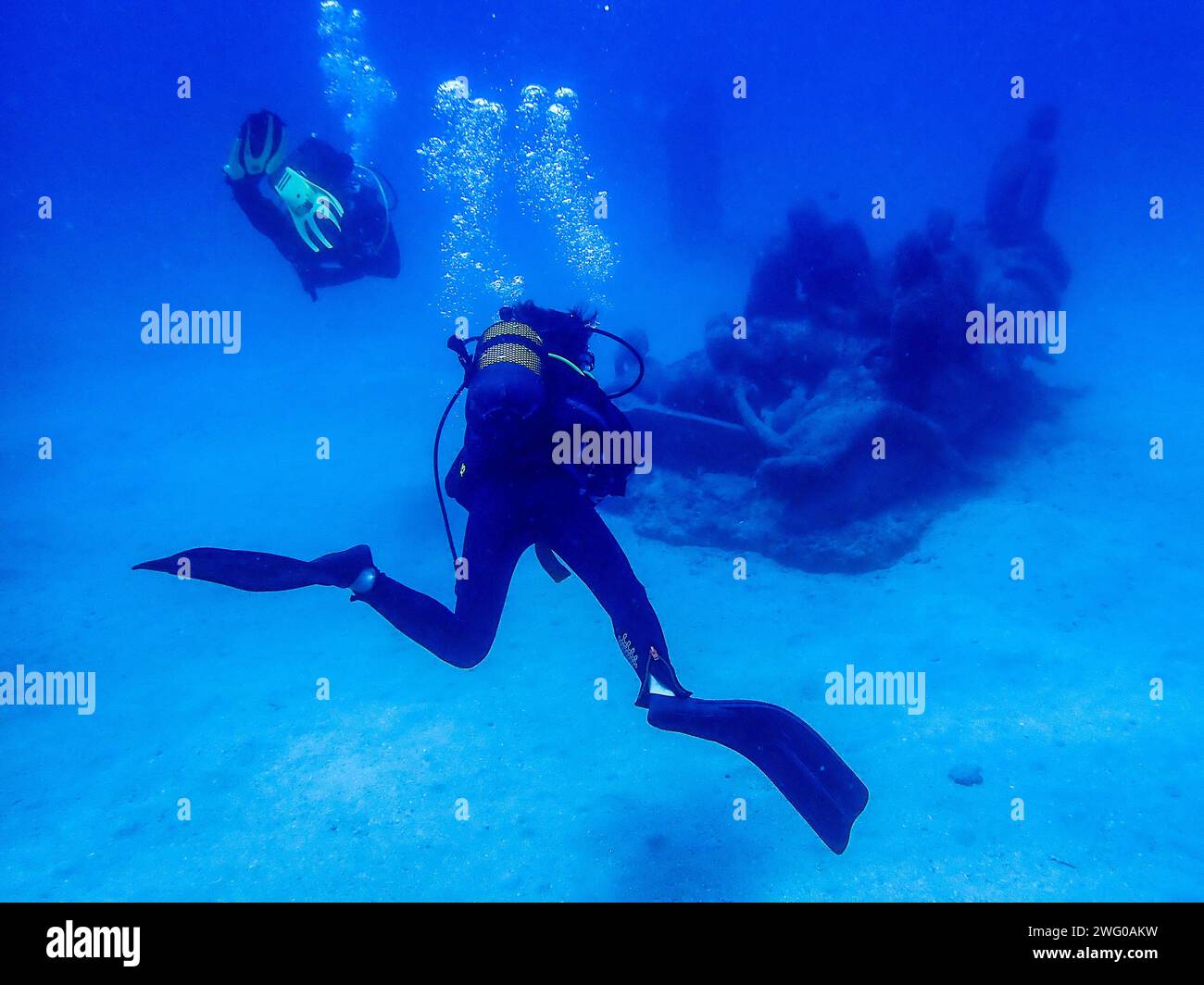 Taucher fasziniert von einer Unterwasserskulptur in den leuchtend blauen Tiefen des Ozeans Lanzarote Stockfoto