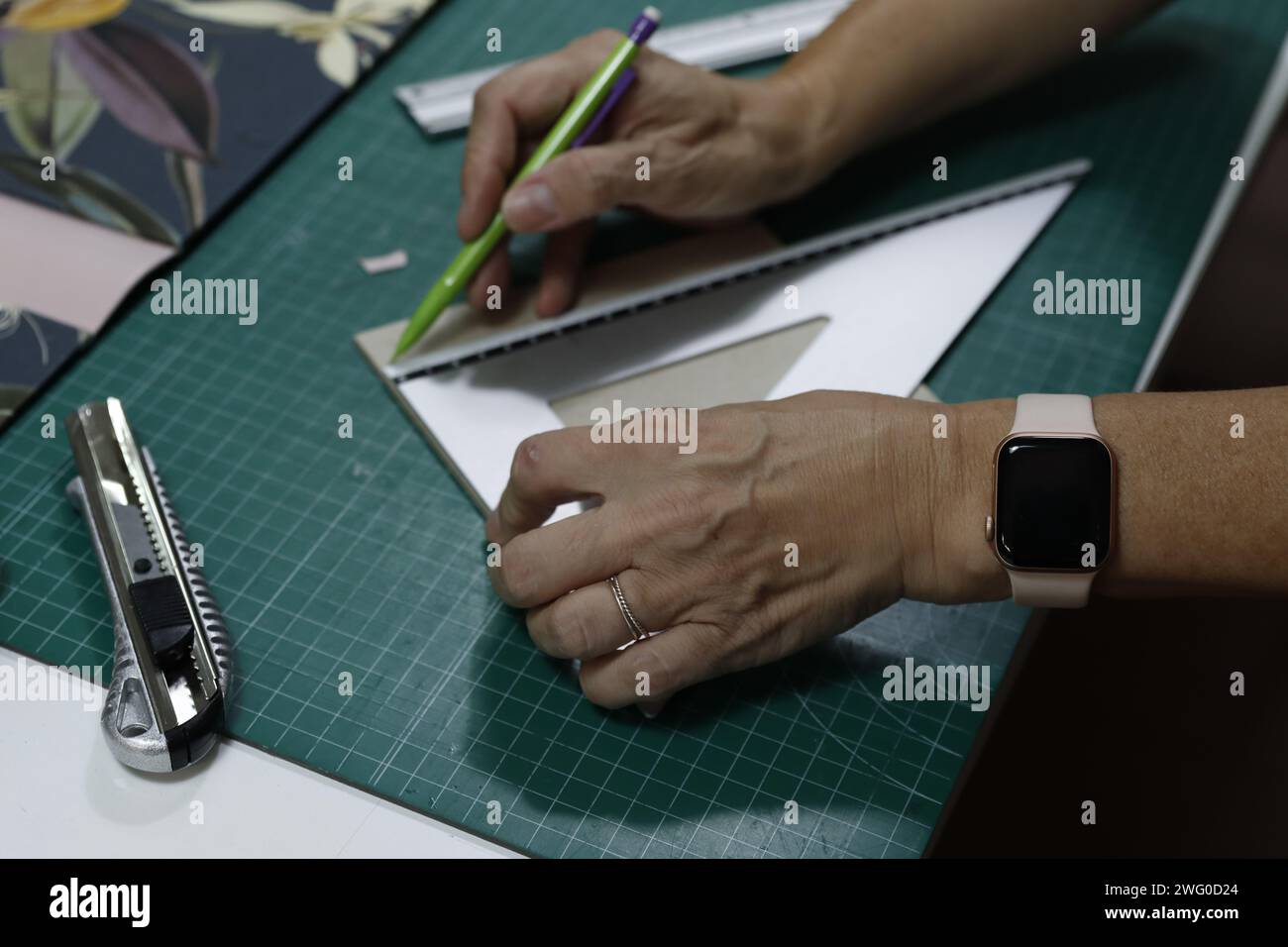 Person, die Papier mit Schere und Stift schneidet Stockfoto