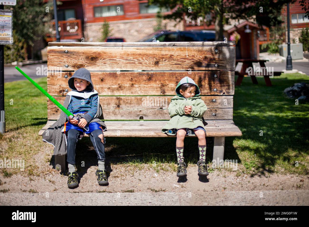 Zwei Brüder sitzen auf Einer Busbank mit ihren leichten Säbeln Stockfoto