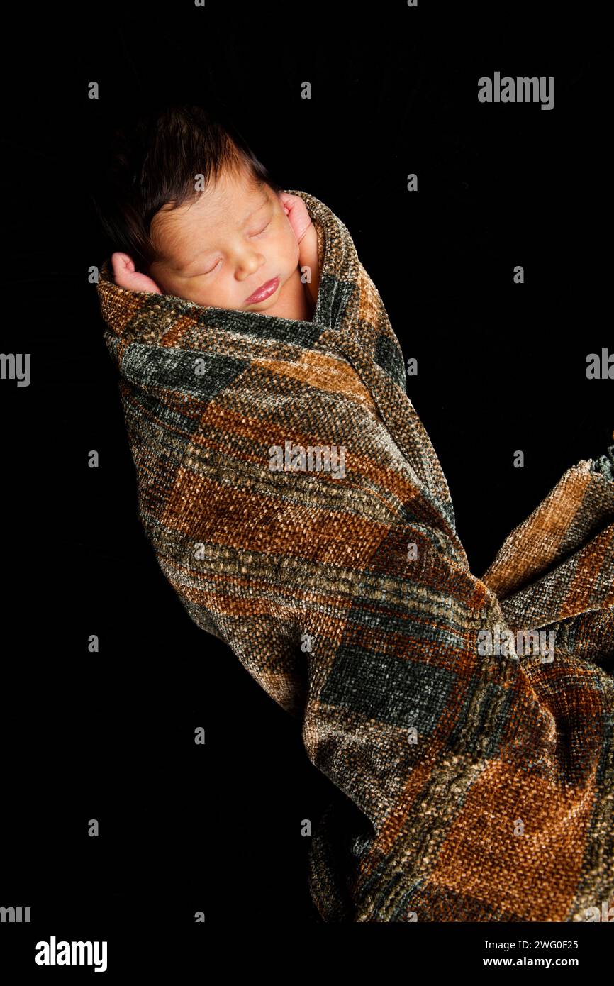 Ein 10 Tage altes japanisches amerikanisches Baby schläft in einer Decke. Stockfoto