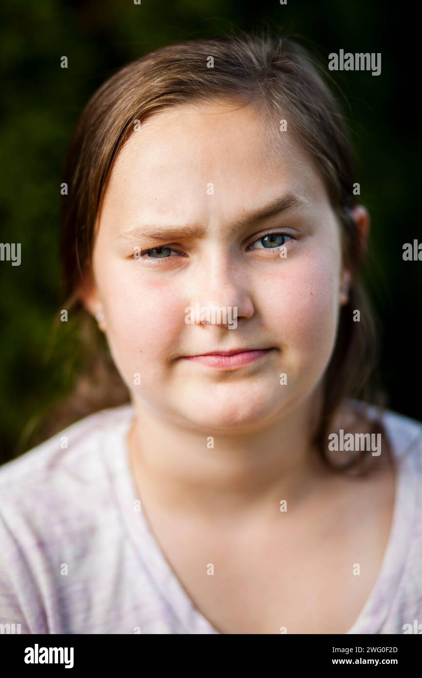 Ein 12-jähriges Porträt hebt die Augenbraue und macht ein neugieriges Gesicht. Stockfoto