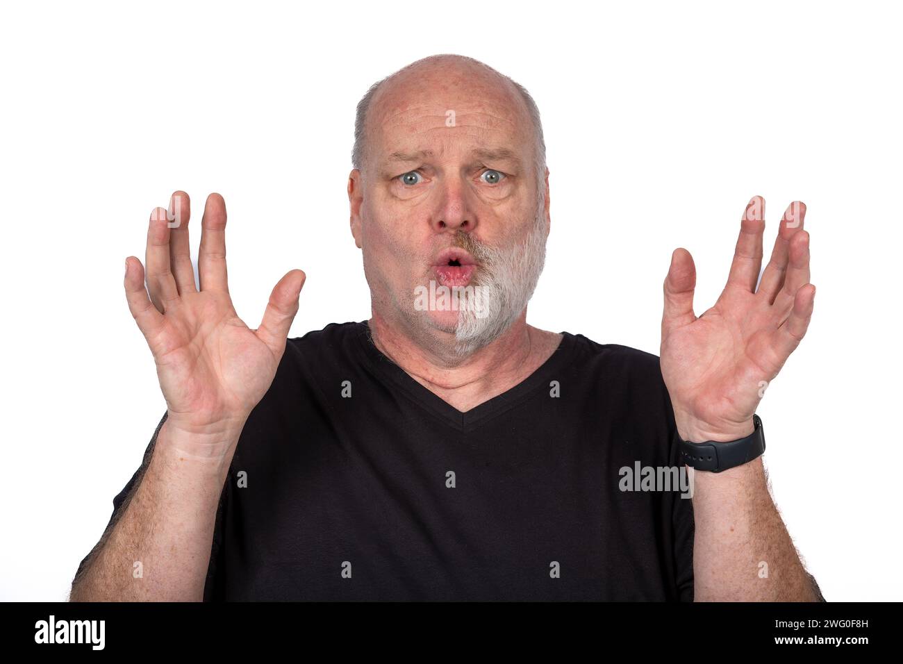 Mann mittleren Alters in Schwarz T-Shirt mit einzigartigem Gesichtsausdruck und erhobenen Händen, ausdrucksstarkes Porträt auf weißem Hintergrund - modernes Lifestyle-Konzept Stockfoto