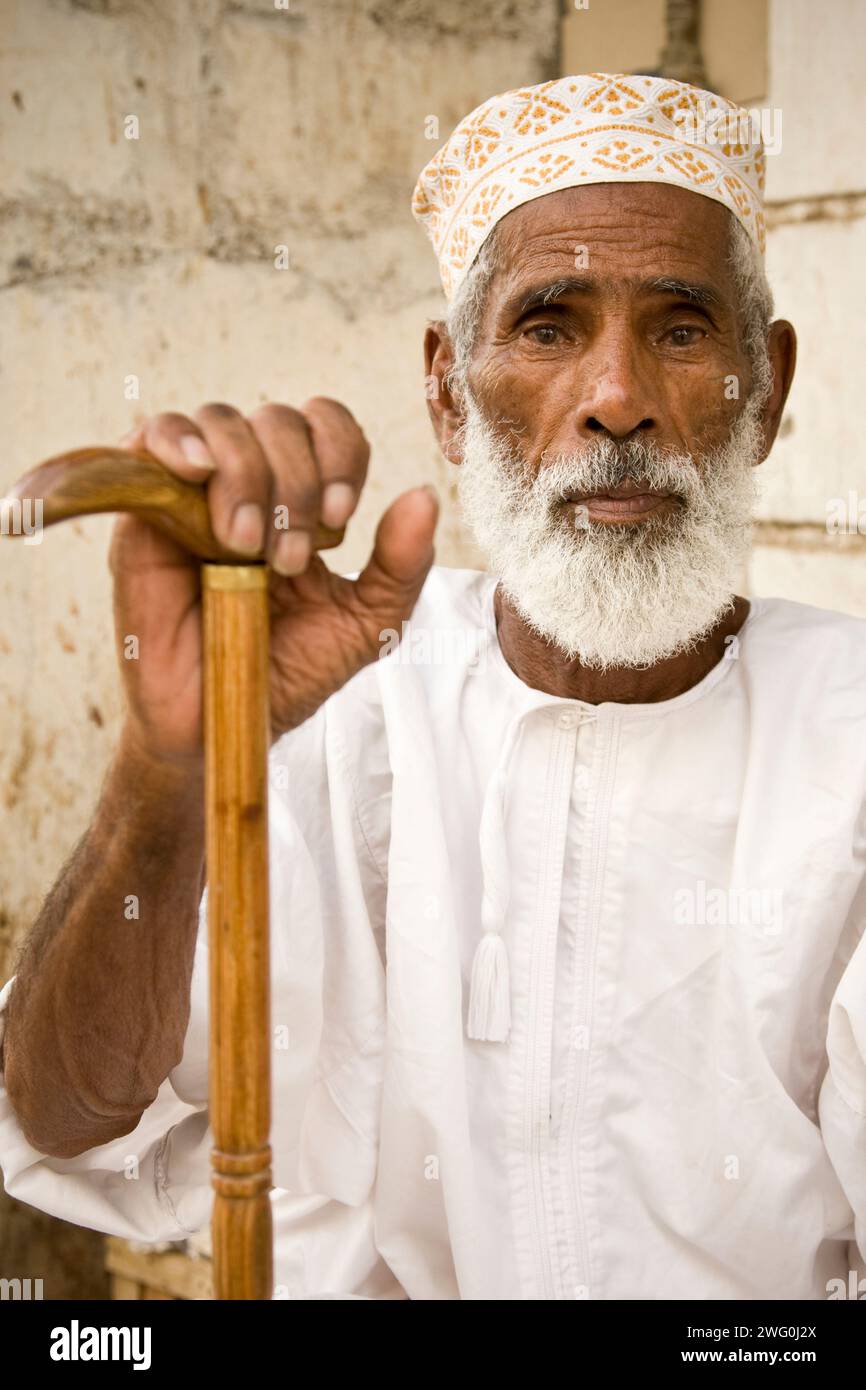 Ein alter bärtiger omanischer Mann in weiß gekleidet im Muttrah Souq in Maskat, Oman. Stockfoto
