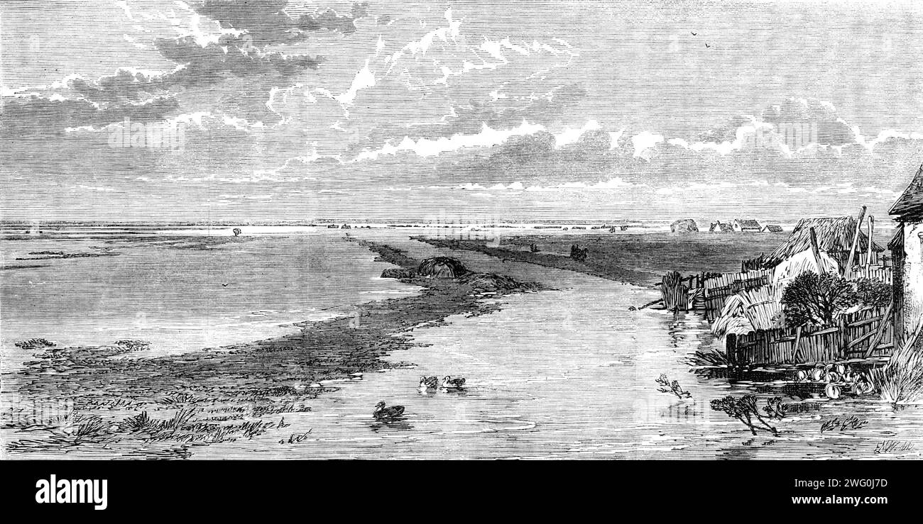 The Flood in the Fens: Blick von der Islington Bridge, 1862. "Vom Gipfel der Mittelebene Eisenbahnbrücke aus wurde fast das gesamte Ausmaß des überfluteten Landes dem Blick präsentiert. So weit das Auge auf jeder Seite, etwa sieben oder acht Meilen lang, das trostlose Wasser hat sich über den Ofen ausgebreitet... unmittelbar vor uns war die Bahn, für eine Entfernung von 3,5 Meilen, unter Wasser. Das Wasser war auf etwa die Hälfte der Höhe der Signale und Telegrafenpfosten gestiegen... hier und da waren die oberen Fenster eines Bauernhauses zu sehen, oder das Strohdach eines bescheideneren Häuschens - die tena Stockfoto