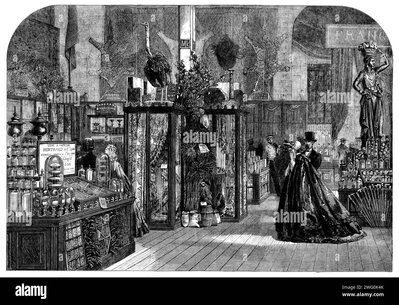The International Exhibition: The Algerian Court - from a Photo by the London Stereoscopic Company, 1862. Es gibt zwei Glaskästen, die Stände aus einem reichhaltigen, transparenten, hauchdünnen Material enthalten, das aus einheimischer Baumwolle gewebt und aufwendig gestickt wurde...[sowie] eine riesige Anzahl von Exemplaren von roher Baumwolle... die aus dieser Baumwolle gewobenen Stoffe stammen von Firmen in Frankreich, die die Herstellung der aufgenommen haben algerische Rohstoffe... es gibt eine beachtliche Auswahl an Weinen, sowohl rot als auch weiß... diese sind natürlich das Ergebnis der französischen Industrie und Herstellung in der Kolonie. Stockfoto