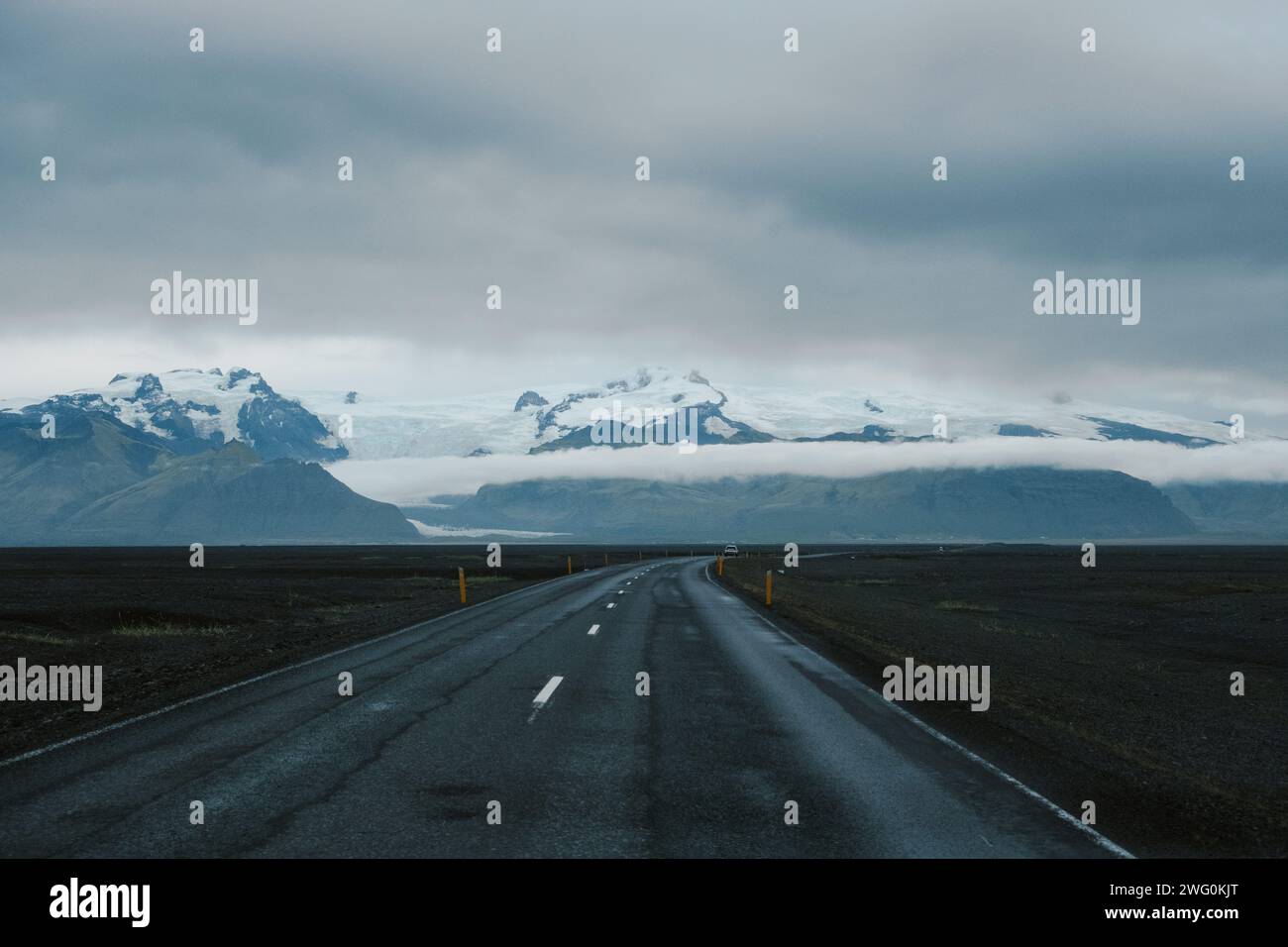 Abgelegene Straße mit malerischem Blick auf die natürlichen, schneebedeckten Berge Islands Stockfoto