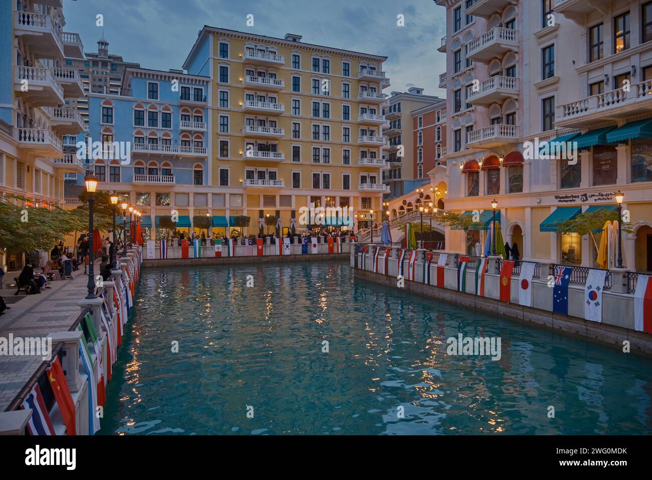 Qanat Quartier in der Perle, Doha Qatar Sonnenuntergang Schuss während des AFC Asian Cup 2023 mit Fahnen der teilnehmenden Teams, einzigartige Architektur von Gebäuden Stockfoto