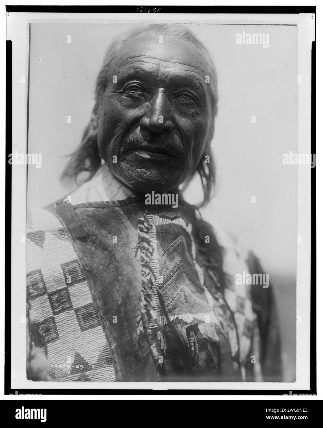 Er Crow-Oglala, 1907. Er Krähe, Oglala Mann, Kopf-und-Schultern-Porträt, nach vorne gerichtet. Stockfoto