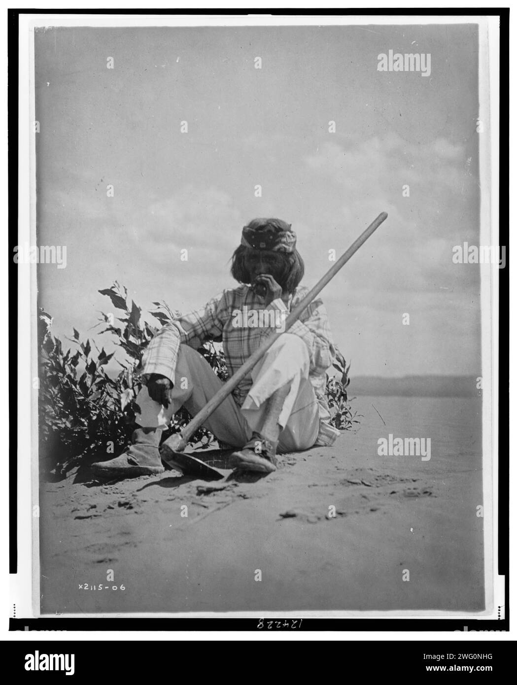 Ein ruhiger Rauch-Hopi, 1907. Hopi-Mann sitzt auf dem Boden und raucht, mit Hacke auf dem linken Knie. Stockfoto