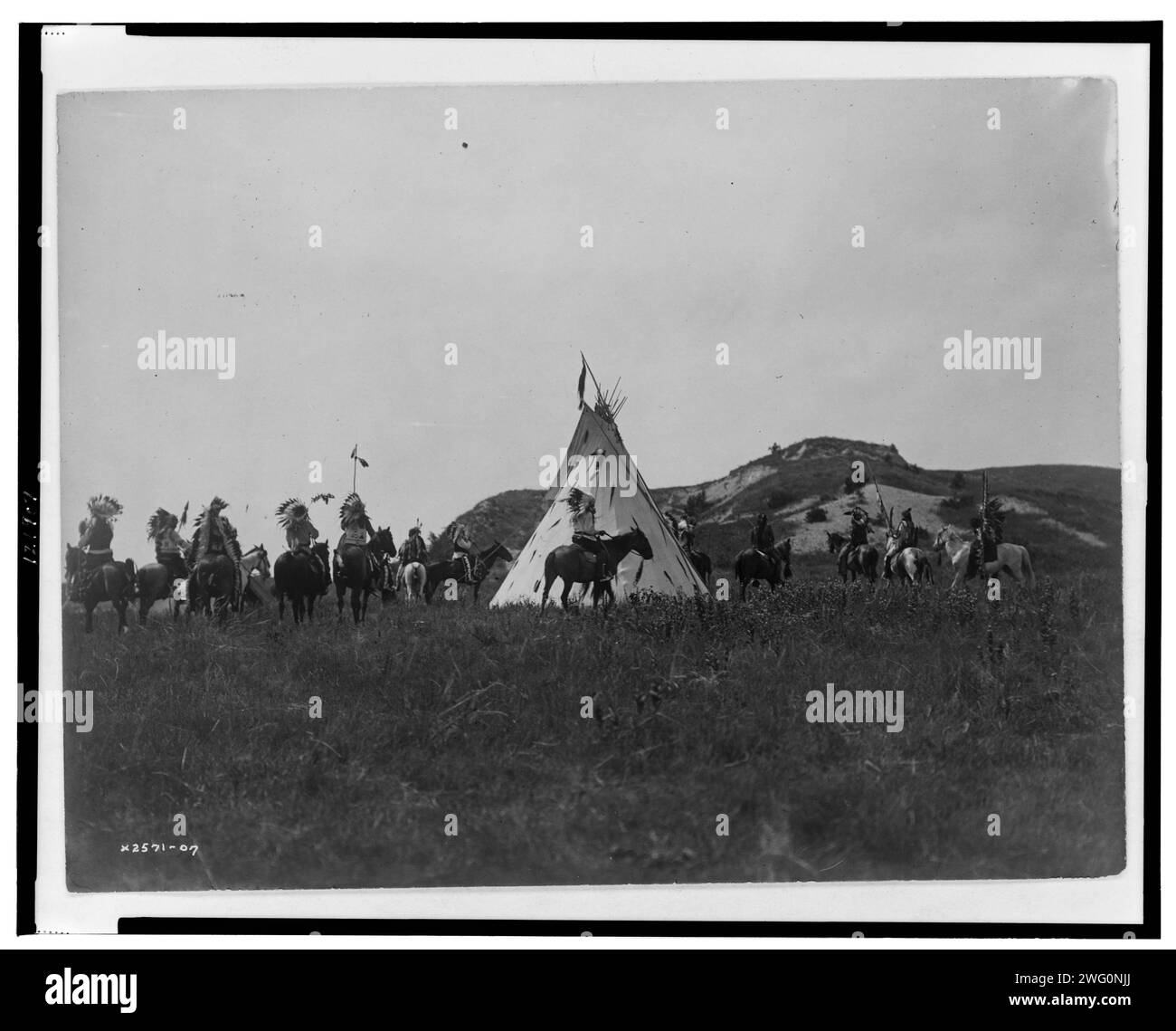 Kriegsvorbereitung, 1907. Mehrere Sioux-Männer zu Pferd versammeln sich vor einem Tipi. Stockfoto
