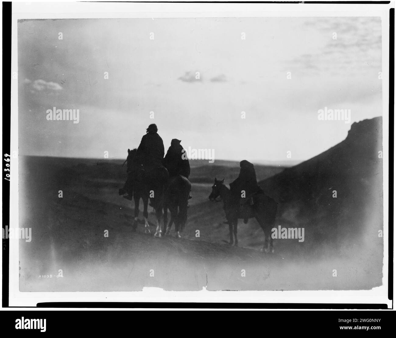 Unter den Black Buttes-Navaho Land, um 1905. Drei Navaho-Indianer zu Pferd, silbrig auf schwarzen Hintern, im Abendlicht. Stockfoto