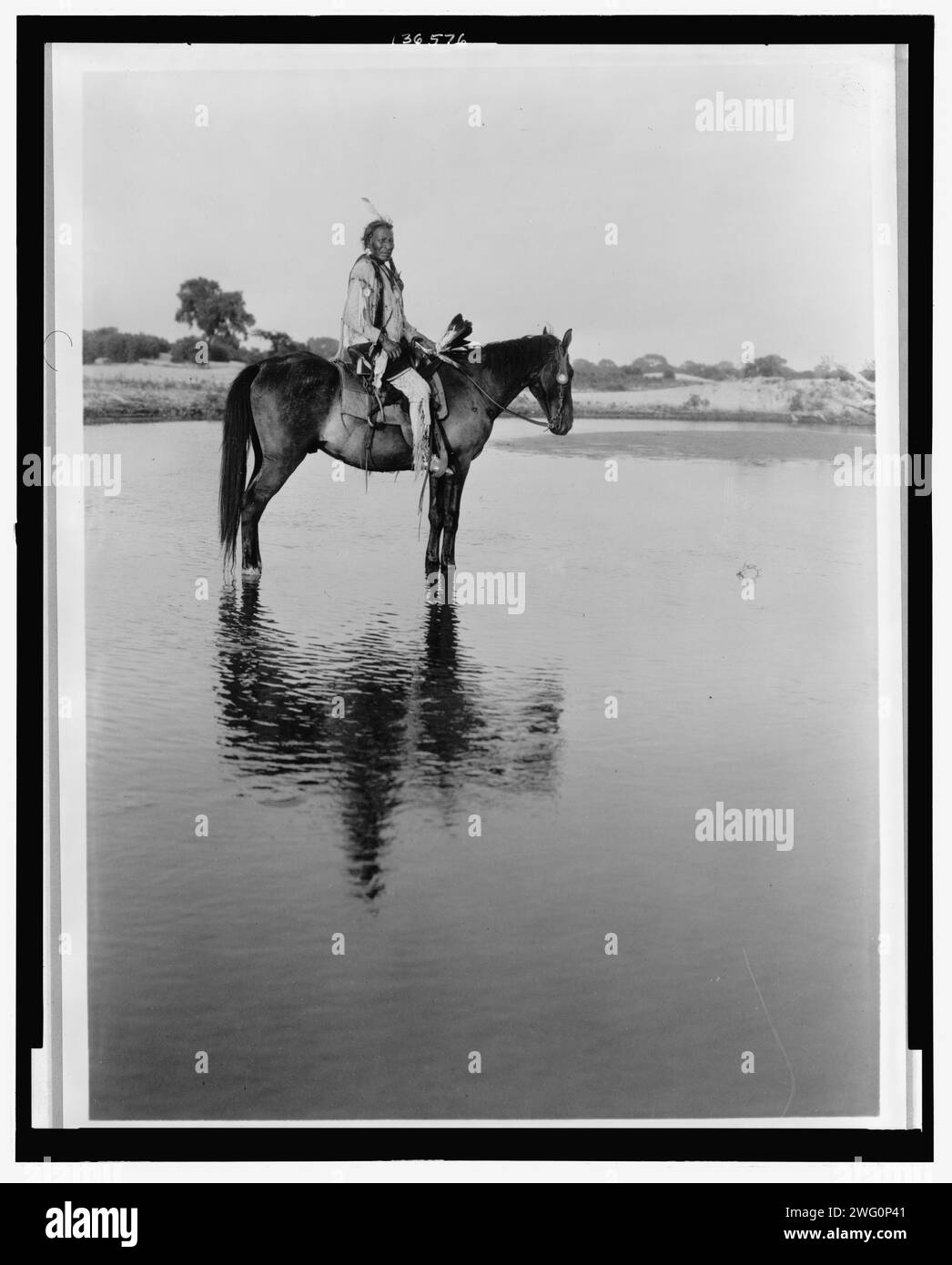 Der einsame Häuptling Cheyenne, 1927. Cheyenne Mann zu Pferd im Flachwasser. Stockfoto