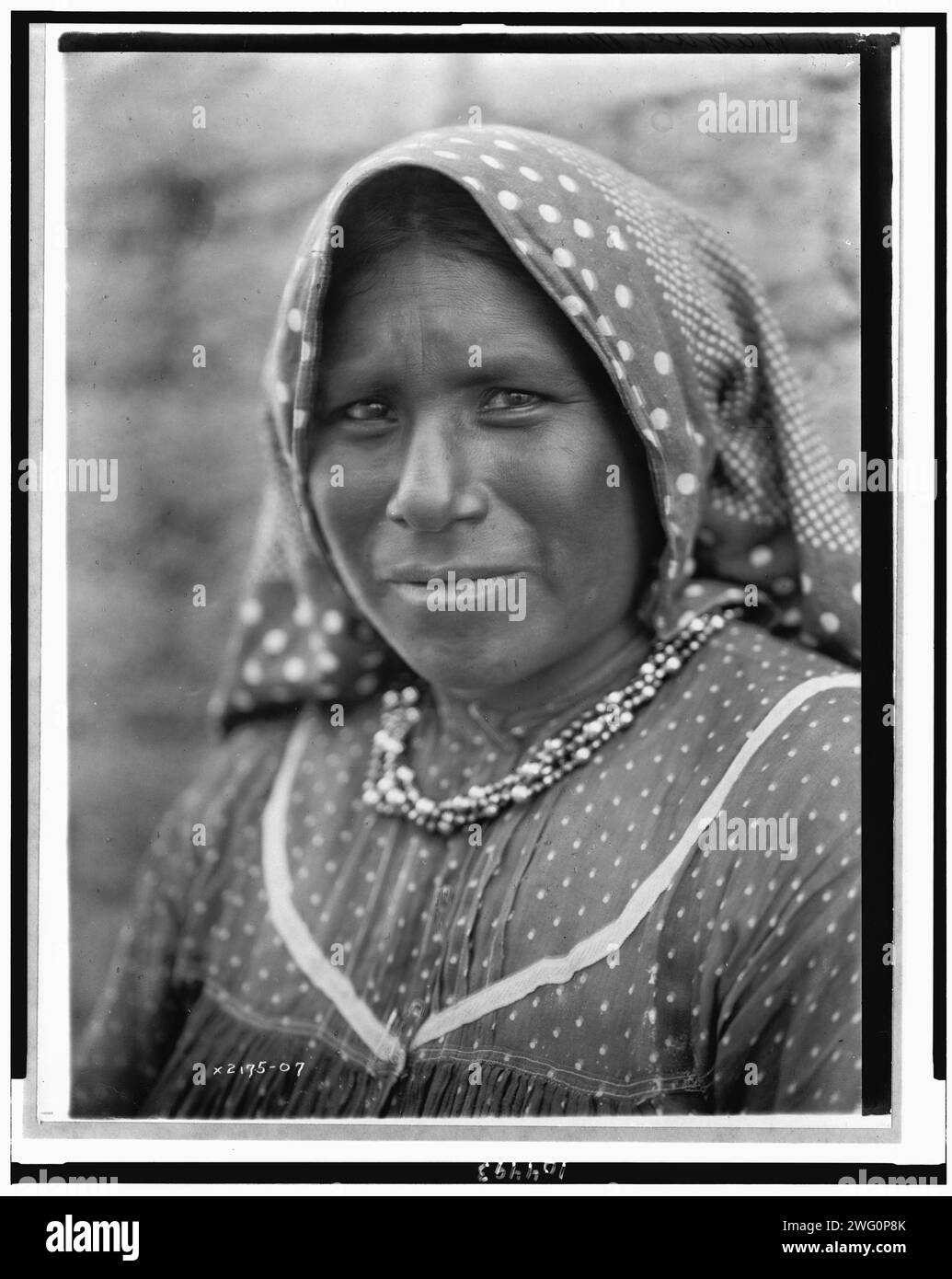 Yaqui Matron, Kopf-und-Schultern-Porträt, leicht nach links gerichtet, mit bedrucktem Baumwollkopftuch, gepunktetem schweizer Kleid, um 1907. Stockfoto