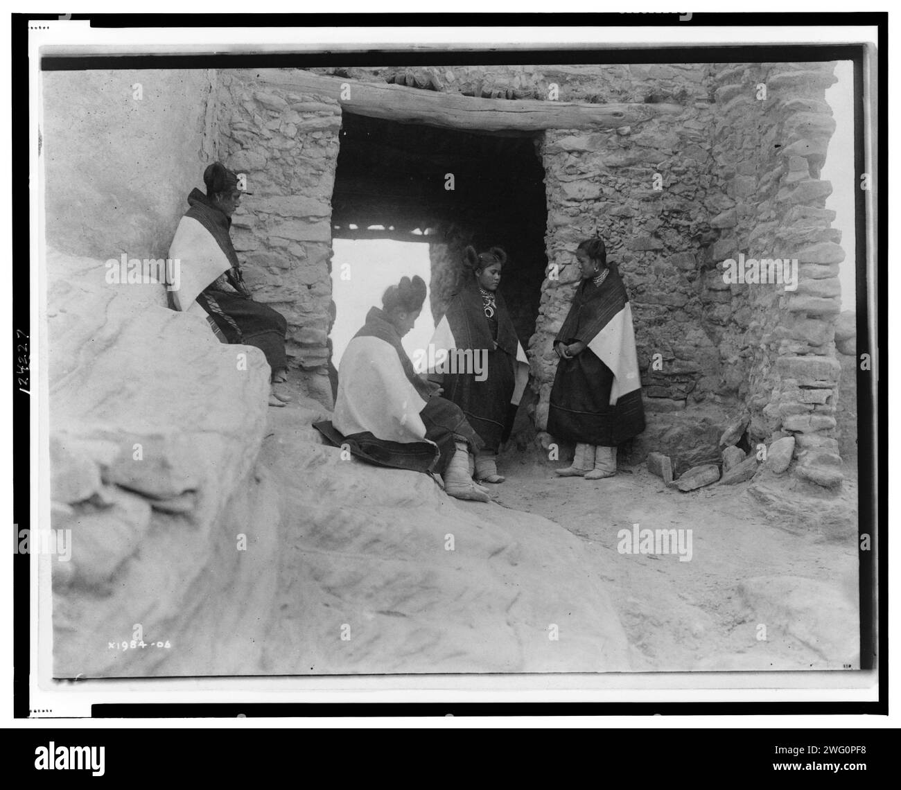 Bescheidene Mädchen, um 1906. Vier junge Hopi-Frauen versammeln sich vor einem Eingang. Stockfoto