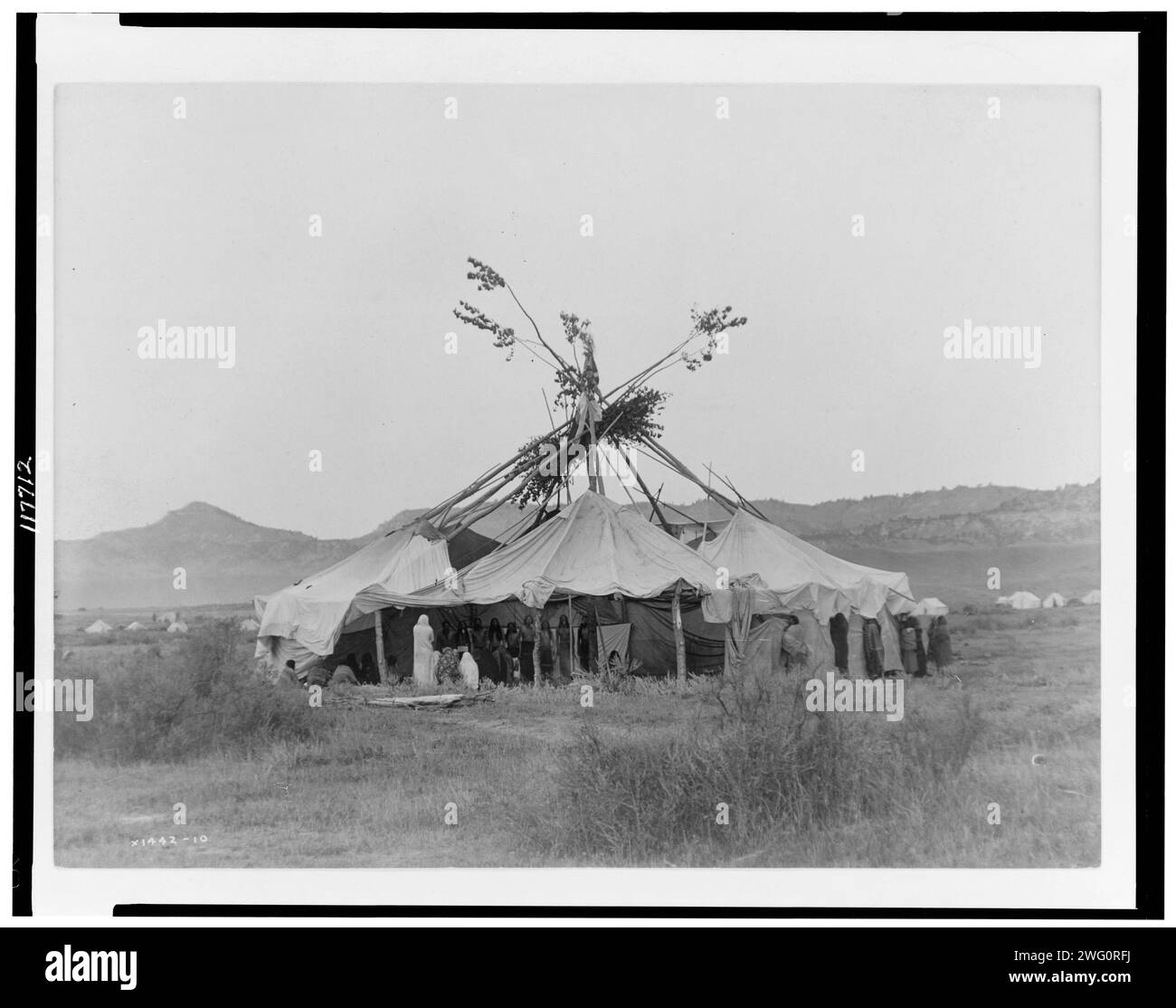 Grey Dawn-Cheyenne, 1910. Sun Dance Lodge mit Cheyenne Leuten, die drinnen stehen. Stockfoto
