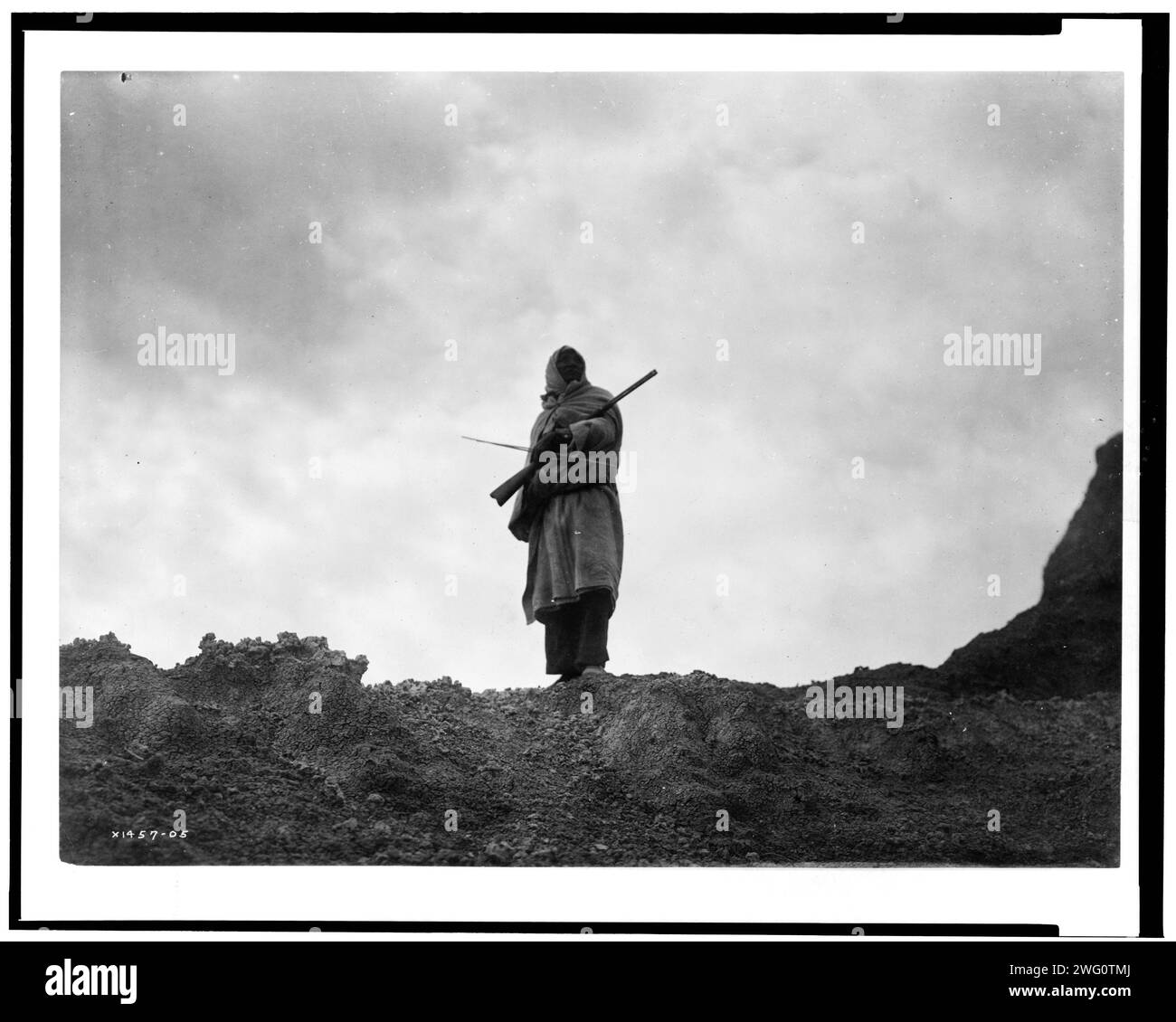 Der Bergschafjäger Sioux, 1905. Ein Mann, der ein Gewehr und einen Bogen hält. Stockfoto