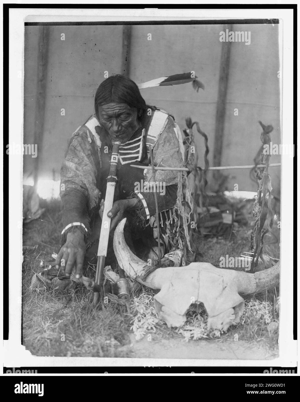 Speichel, c1907. Dakota-Mann mit calumet kniend vor dem Altar in Tipi. Stockfoto