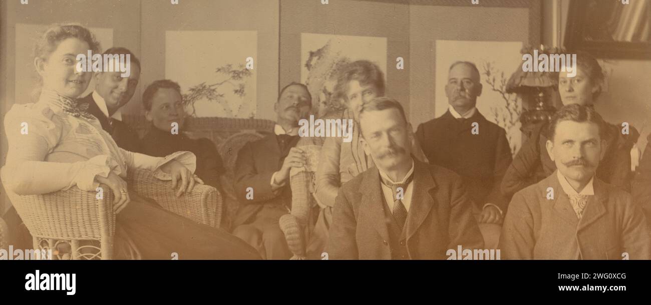 Ein geselliges Treffen auf der Veranda, Dom Smith, Wladiwostok, Russland, 1899. Das Gruppenporträt zeigt Personen, die in Eleanor Pray's Brief vom 14. Juli 1899 beschrieben wurden: „Ich schicke euch zwei Blaupausen von Mr. [David] Clarksons Negativen. Der, der in unserem Morgenzimmer aufgenommen wurde, soll der Beste von mir sein, der genommen wurde. Ich bin am Ende, dann Mr. Johns (aus Chicago), Mrs. [Sarah] Smith, Mr. Bell, Mrs. Bunker, Mr. Bunker (aus San Francisco), Mrs. Johns, Fred [beten, ganz rechts] und Mr. Miller [Mitte vorne]. Der Ellbogen rechts ist an Mr. Davidson befestigt, aber er kam nicht heraus, weil er nicht rauskam Stockfoto