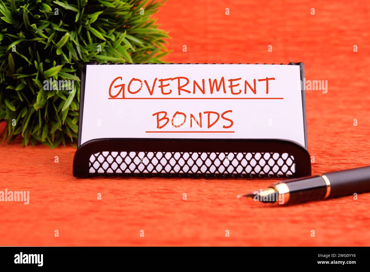 Text für Staatsanleihen auf einer weißen Karte auf einem Stand auf orangem Hintergrund Stockfoto
