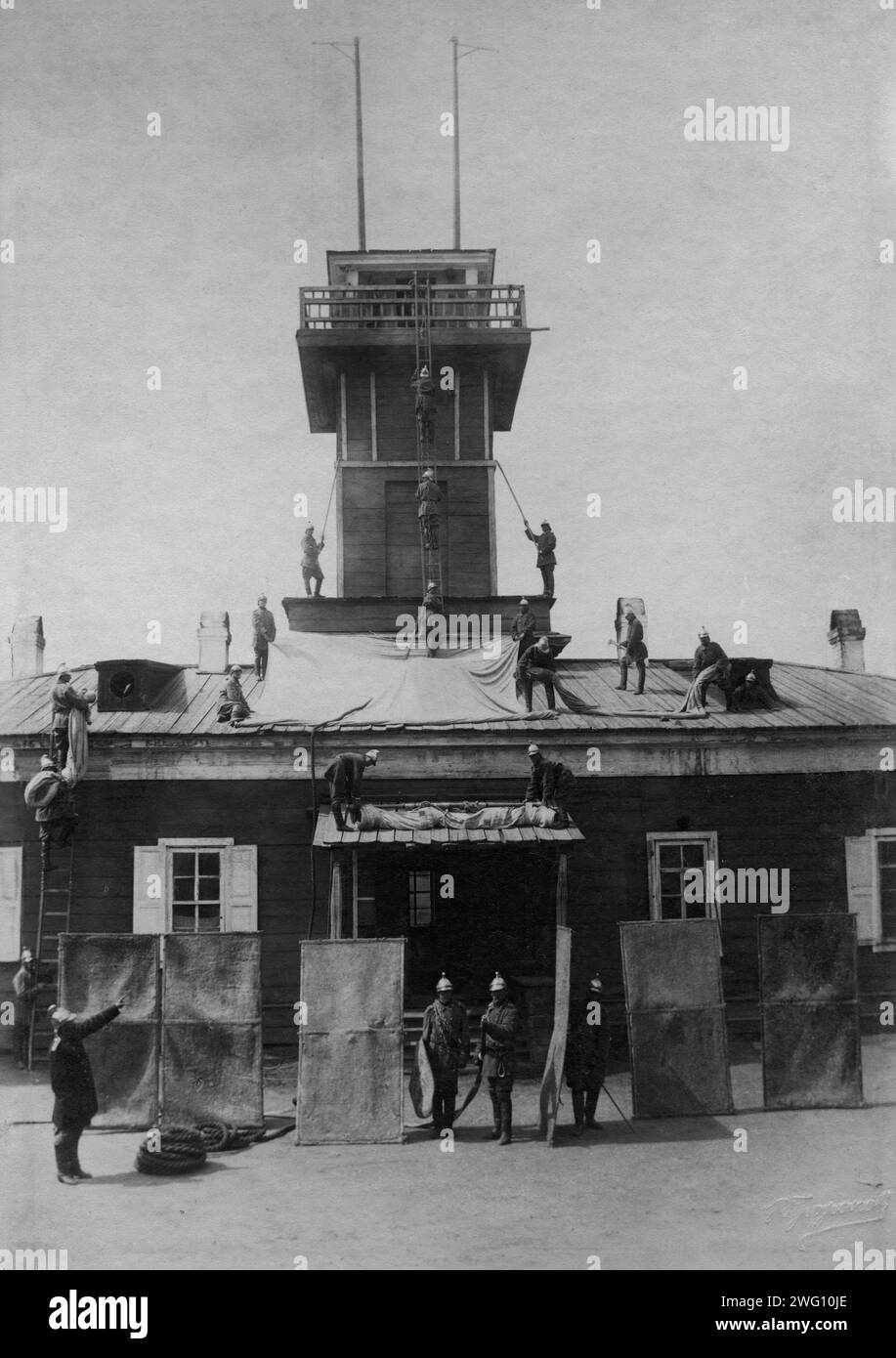 Die Feuerwehr der Polizei Irkutsk. Übung mit Planen, Schilden, Brecheisen und Haken, 1894. Diese Sammlung von Fotografien und Dokumenten aus dem Privatarchiv von Sergej Michailowitsch Tschashchin bezieht sich auf die Einrichtung einer Feuerwehrstation in Ostsibirien im 19. Und frühen 20. Jahrhundert. Es umfasst Materialien über die Ausrüstung zur frühzeitigen Brandbekämpfung, die Organisation eines sibirischen Löschteams und die Leiter der ersten sibirischen Feuerwehr. Stockfoto