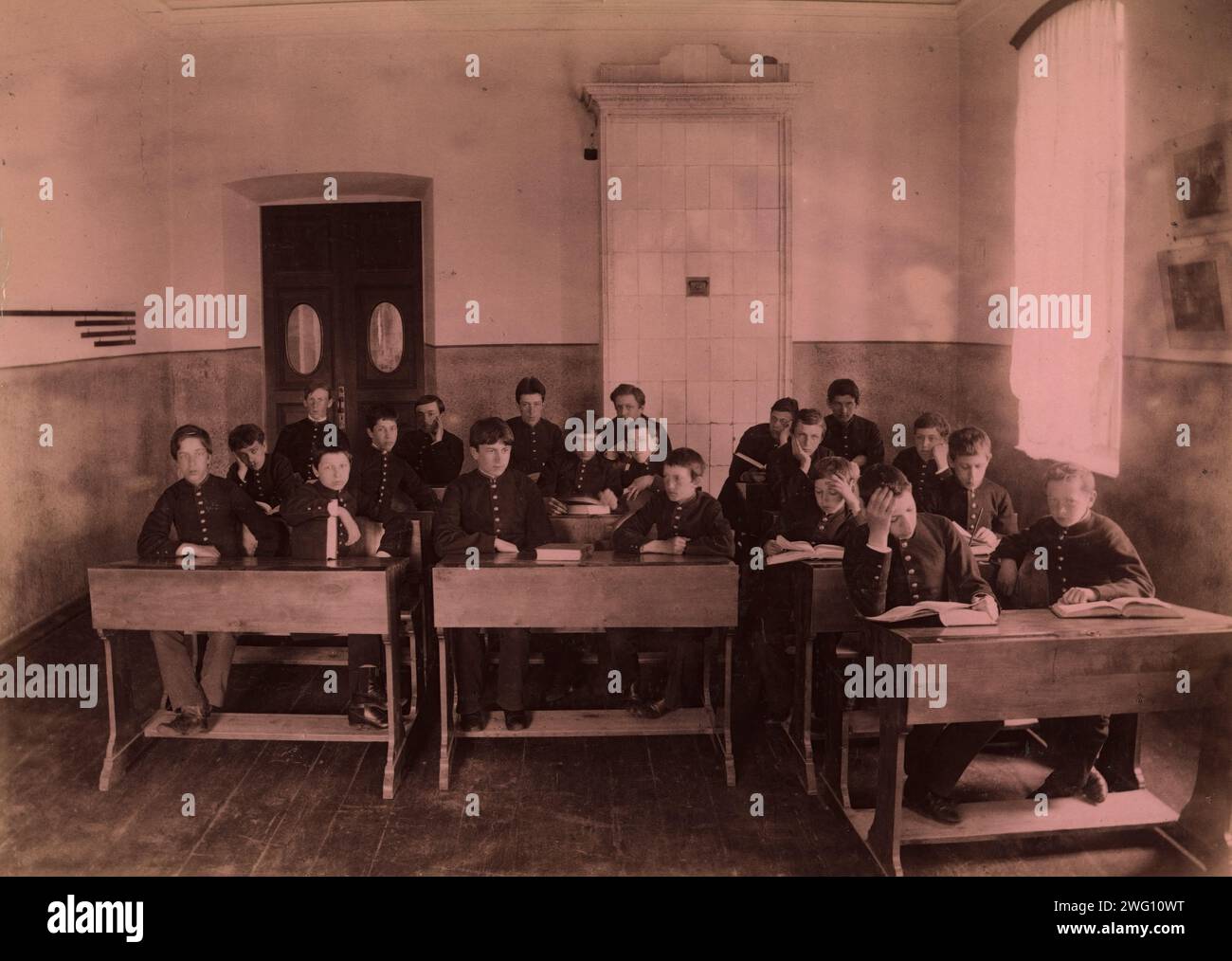 Klassenzimmer während eines Unterrichts, 1889. Aus einem Fotoalbum der Aleksandrowski-Schule in der sibirischen Stadt Tiumen (heute Tjumen). Die Schule, die junge Männer von der ersten bis zur sechsten Klasse ausbildete, war von 1879 bis 1919 tätig. Sie wurde auf Initiative des sibirischen Generalgouverneurs Nikolai Gennadievich Kasnakow (1823–85) gegründet. Durch ein Projekt des amerikanischen Journalisten und Entdeckers George Kennan (1845–1924) erhielt die Schule Ausrüstung vom Massachusetts Institute of Technology. Die Schüler der Schule erhielten Russisch, Deutsch und Französisch, verschiedene Stockfoto