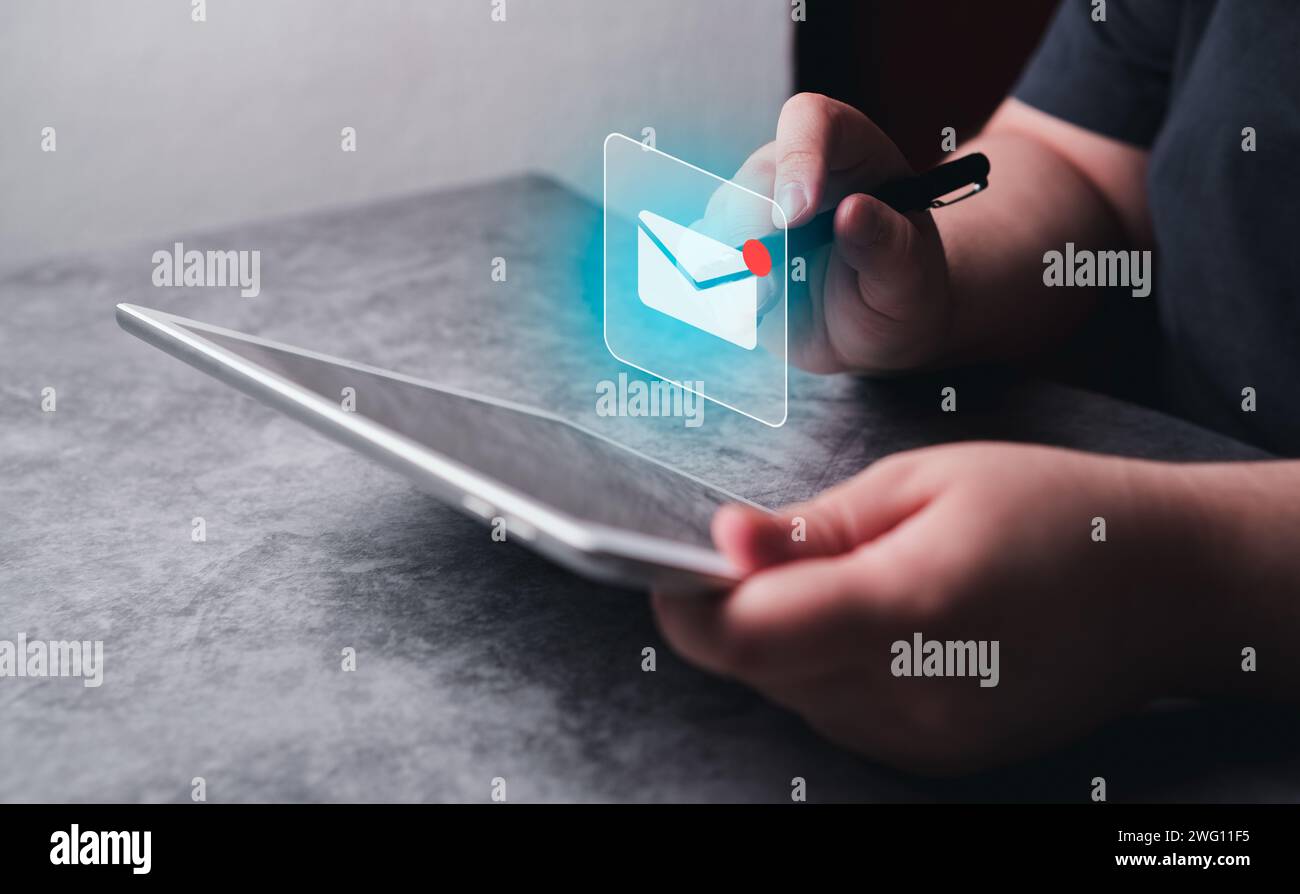 Frauen verwenden ein digitales Tablet mit Hologramm-E-Mail-Symbol-Schnittstelle. E-Mail-Marketing-Konzept. E-Mail oder Newsletter senden. Stockfoto