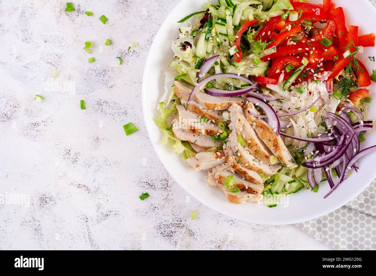 Frischer Salat mit gegrillter Hähnchenbrust, Filet und Salat, Daikon, roten Zwiebeln, Gurke und Sesam. Gesundes Mittagsmenü. Diätkost. Draufsicht Stockfoto