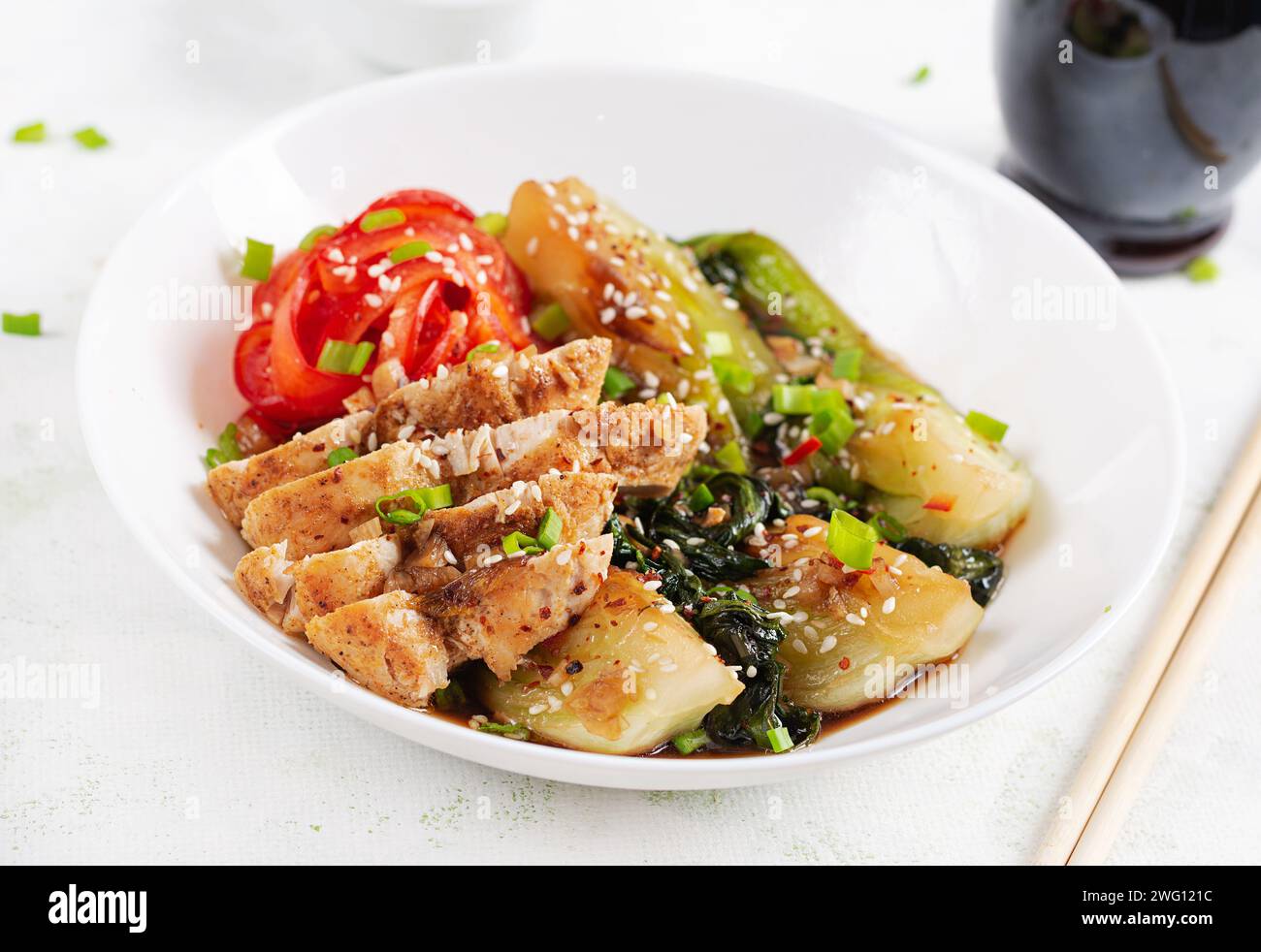 Gebratenes Hühnchen, süße Paprika und Pak Choy in einer Schüssel auf dem Tisch verrühren. Braten Sie pak Choi unter Rühren. Asiatisches Essen. Stockfoto