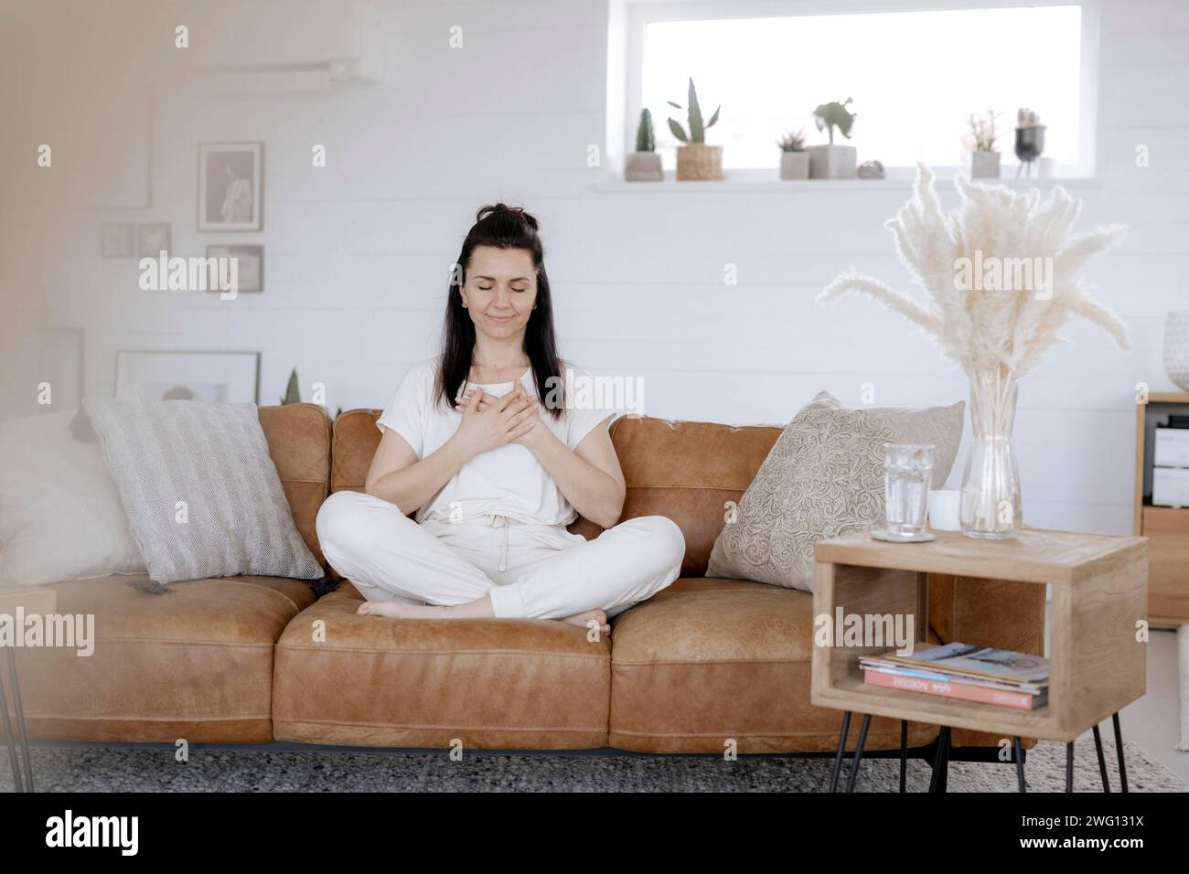 Frau, 40, macht Entspannungsübungen auf einer Couch Stockfoto