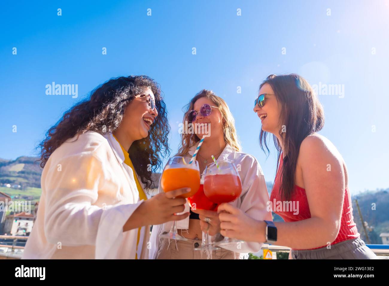 Freunde, die im Sommer auf einer Dachterrasse feiern, Cocktails trinken und plaudern Stockfoto